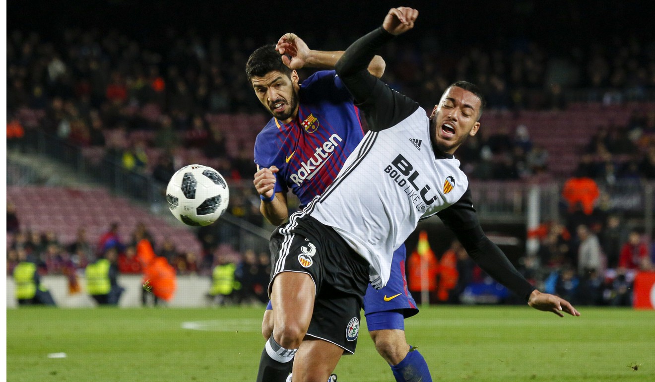 Barcelona's Luis Suarez (Back) vies with Valencia's Ruben Vezo during the Spanish King's Cup. Photo: Xinhua