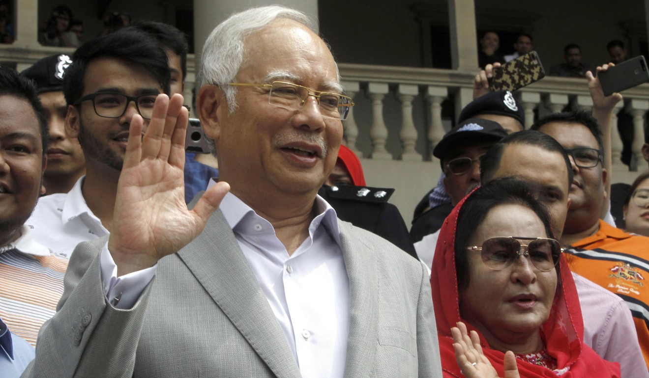 Former Malaysian prime minister Najib Razak and his wife, Rosmah Mansor, wave to their supporters as they exit the High Court of Malaya, in Kuala Lumpur, Malaysia, on July 9. Photo: AP