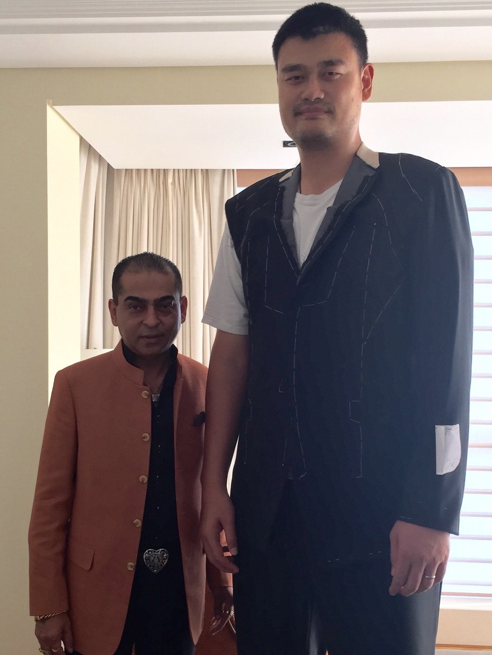 Tony the tailor with NBA legend Yao Ming, the “tallest person he ever had to dress”. Photo: Handout