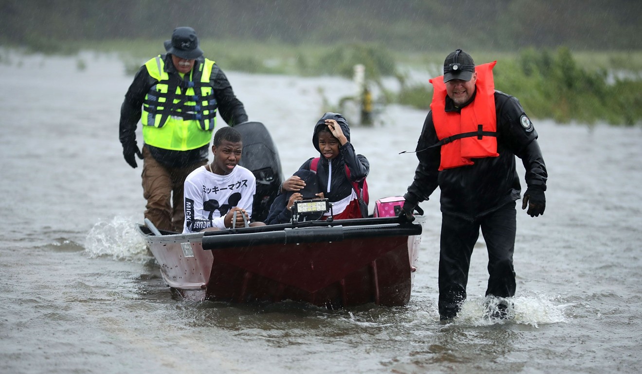Volunteers from the Civilian Crisis Response Team help rescue three children from their flooded home on Friday in James City, North Carolina. Photo: AFP