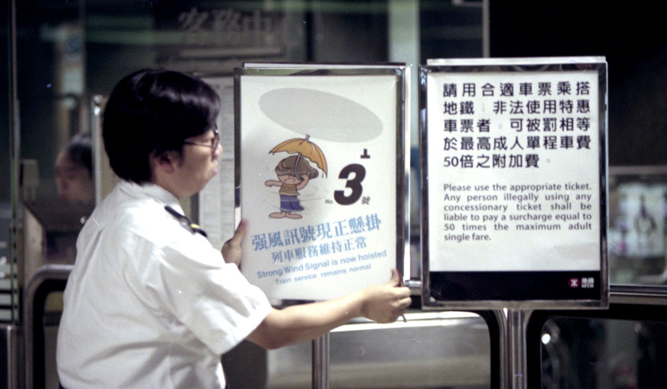 An MTR staff puts up a warning signal No 3. Photo: Dustin Shum