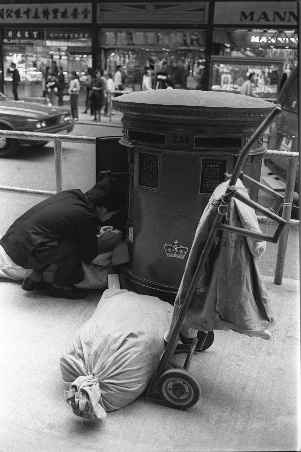 A postman collects letters from a roadside postbox in Central in the 1980s. Photo: Sunny Lee
