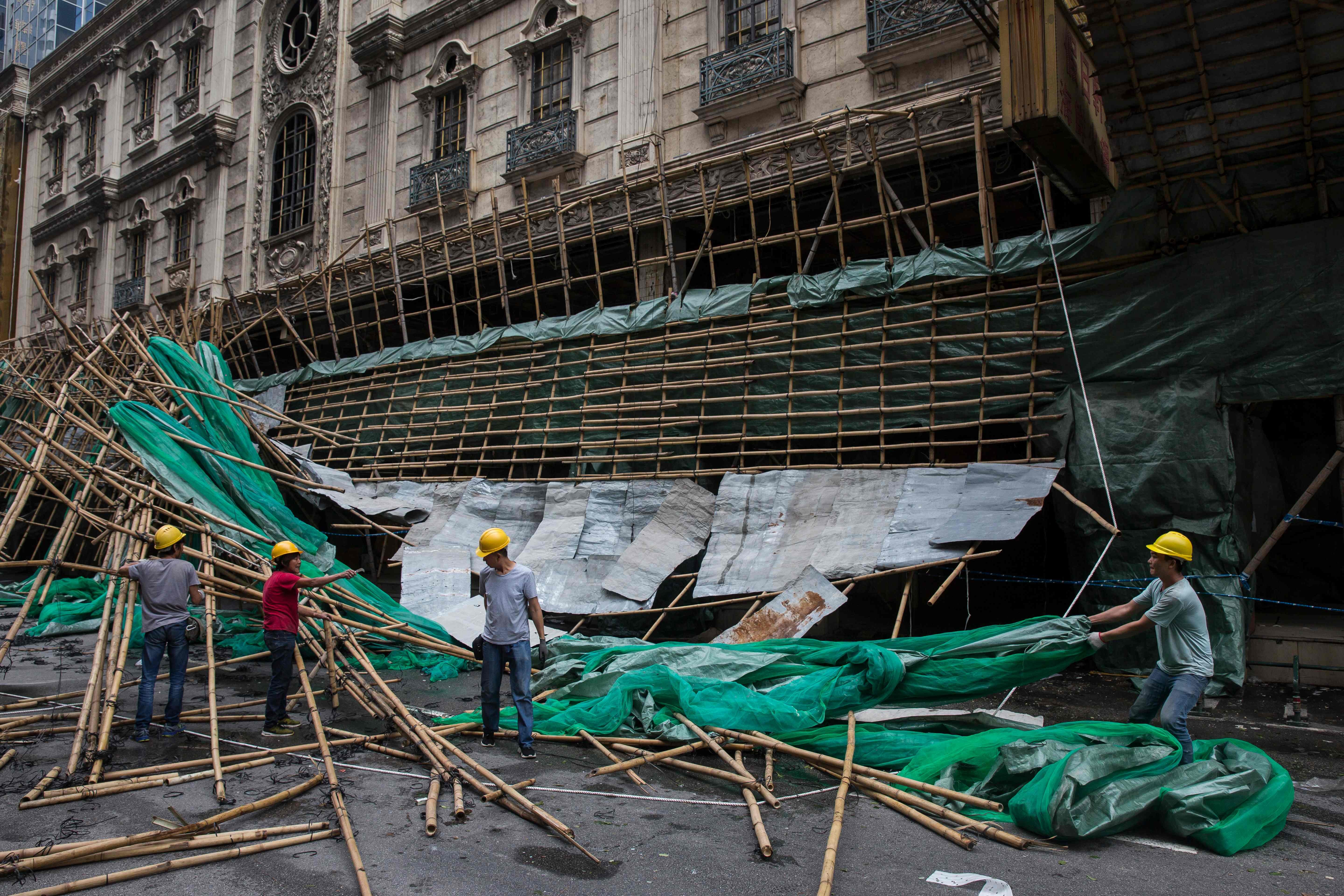 Bearing the brunt: Macau workers clear up scaffolding brought down by strong winds, a day after Typhoon Mangkhut hammered there, Hong Kong and southern China. Photo: AFP)