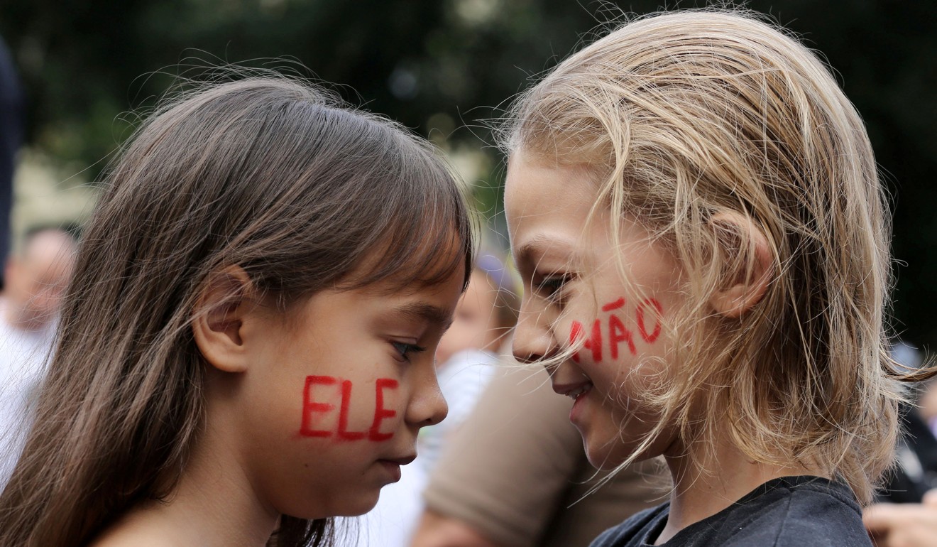 Children are seen with “Not Him” painted on her faces during demonstrations against presidential candidate Jair Bolsonaro, in Rio de Janeiro. Photo: Reuters