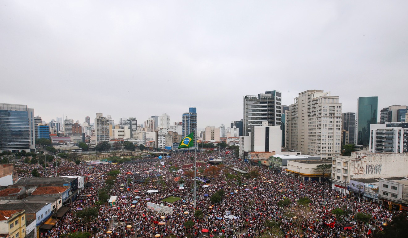 People gather during a demonstration in Sao Paulo, Brazil, where tens of thousands are protesting a right-wing presidential candidate.