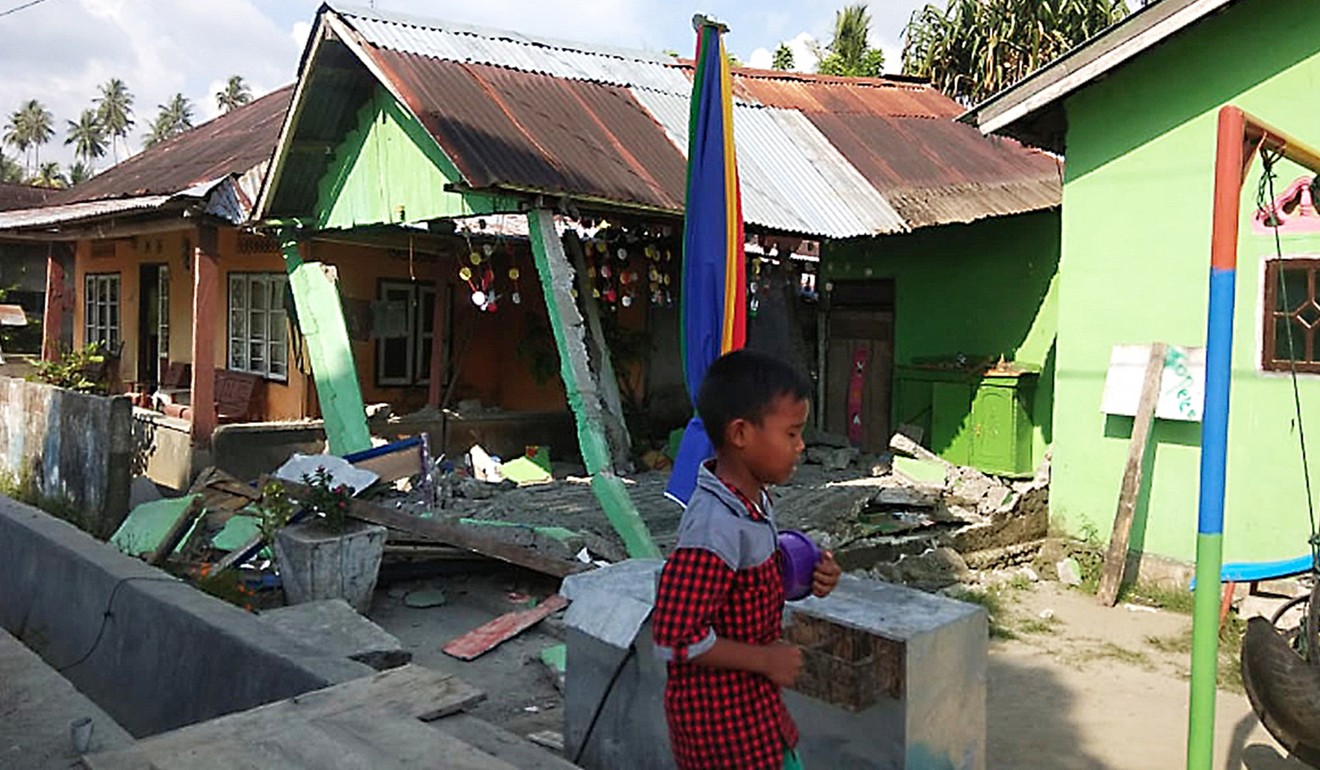 A boy walks past collapsed house in Donggala, Indonesia's Central Sulawesi province, where thousands are believed to be missing after the tsunami. Photo: Tribune News Service