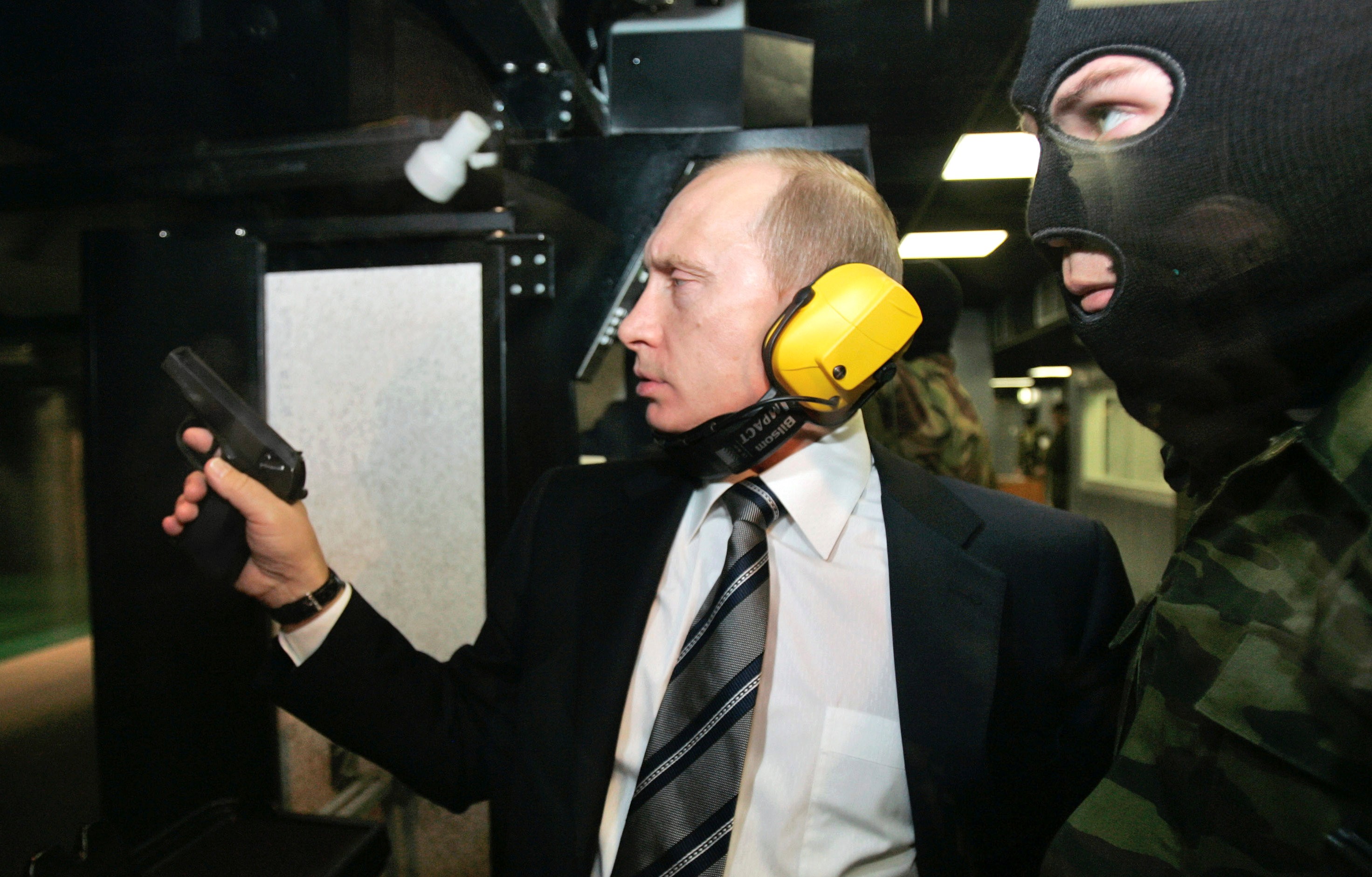 Russian President Vladimir Putin and a masked security officer at a shooting gallery in Moscow. Photo: Reuters