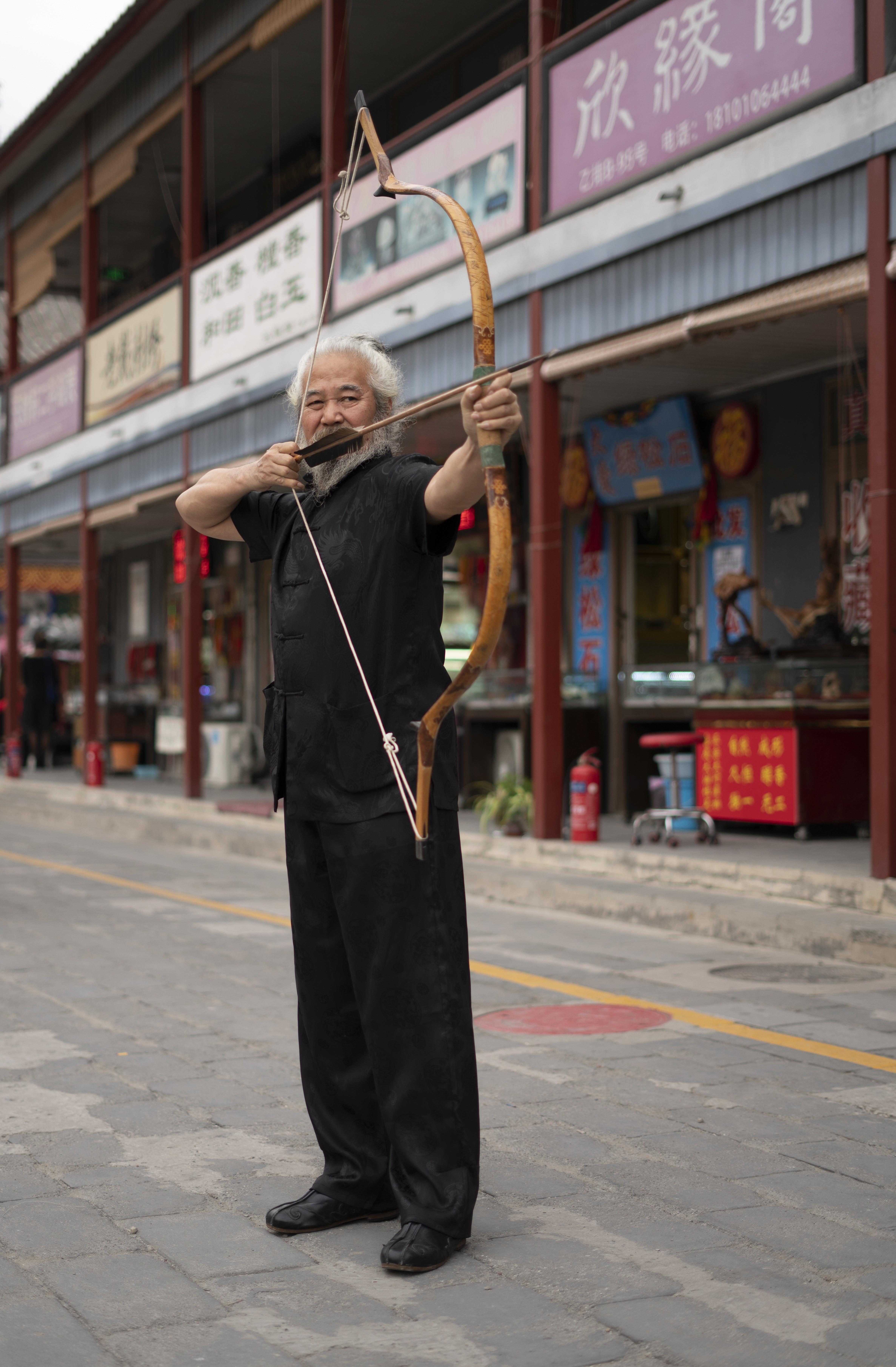 Yang Fuxi with one of his traditional Chinese ox-horn bows, in Beijing’s Panjiayuan Market last month. Picture: Steven Ribet