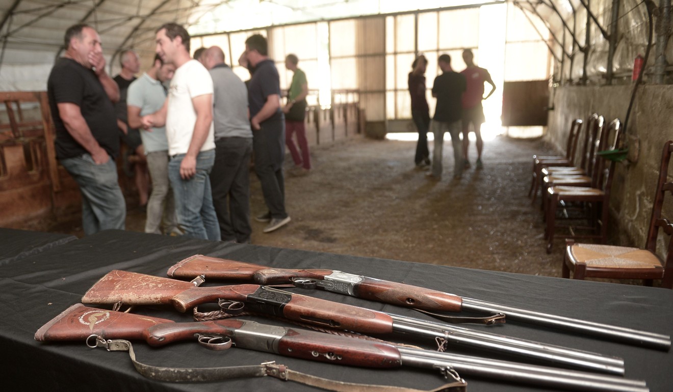 Farmers chat, with their rifles set on a table, during de Rugy’s visit on September 20. Photo: AFP