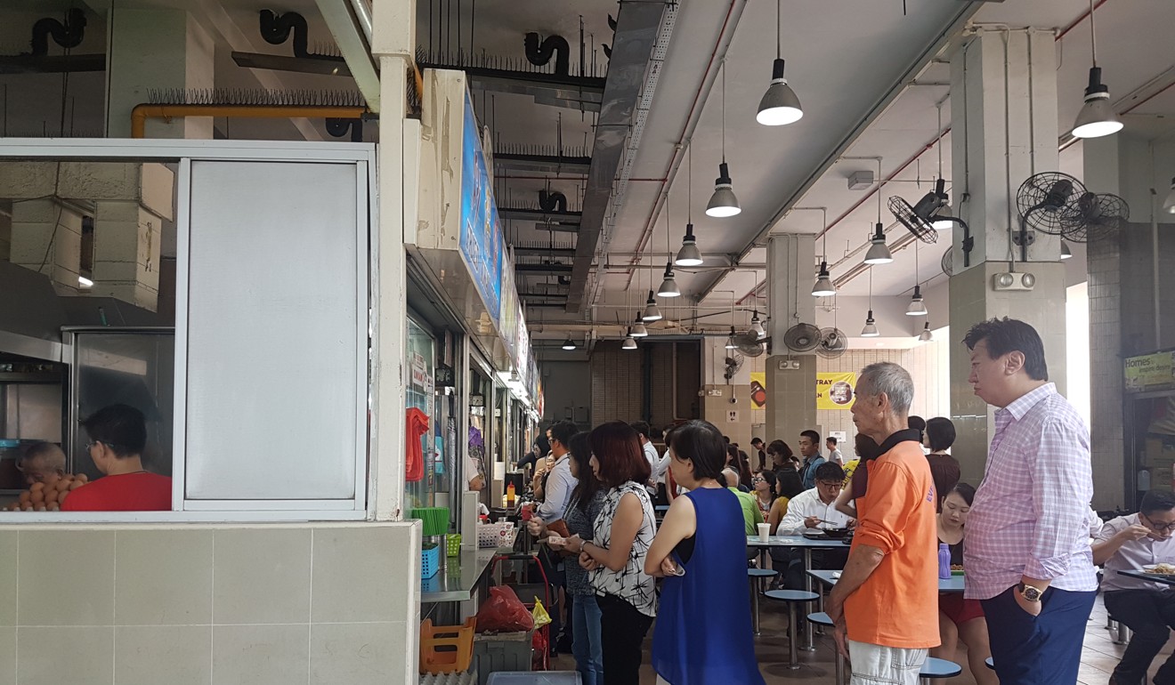 People queuing at a stall in Amoy Street Food Centre with cash in hand. Photo: Samantha Boh