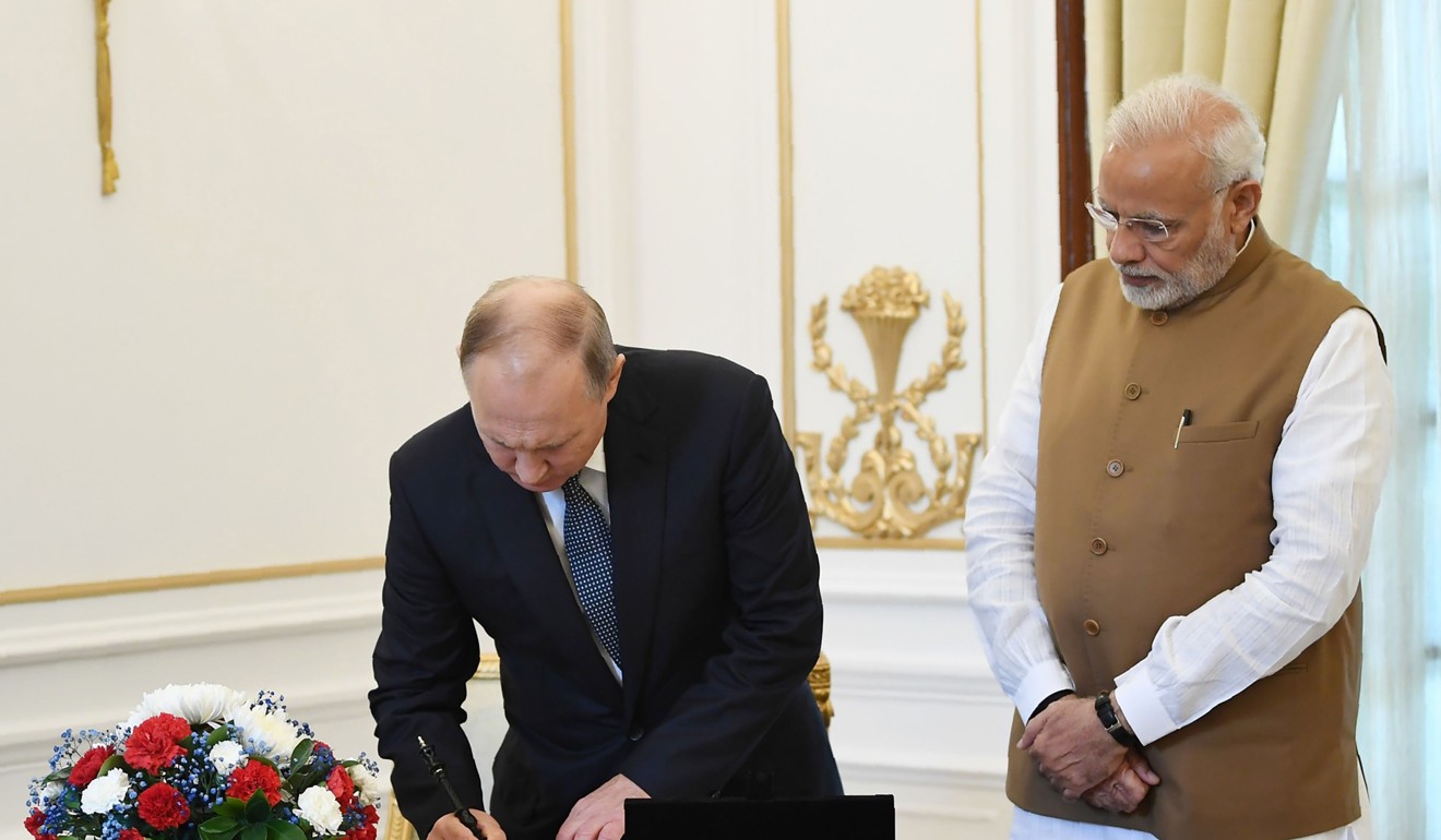 Putin, left, signing the visitors book as Modi looks on at the Hyderabad House in New Delhi. Photo: Handout
