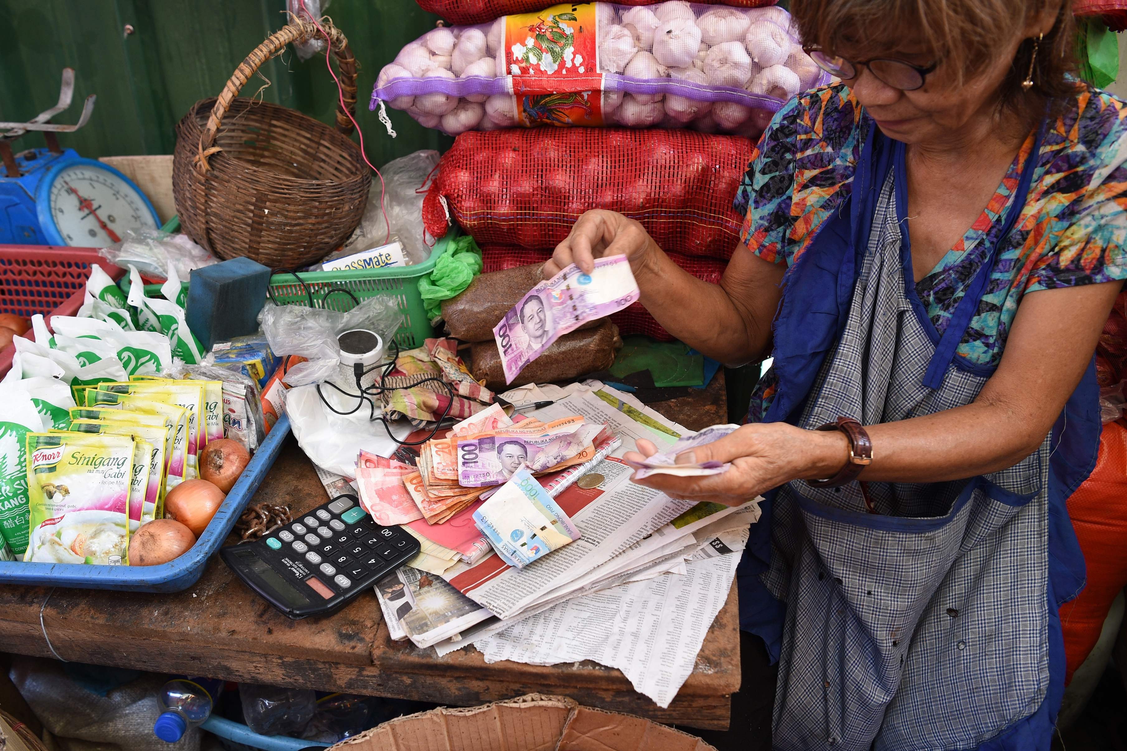 A vendor counts her earnings at a market in Manila – Philippine inflation rose for a ninth straight month in September, to a near-10-year high. Photo: AFP