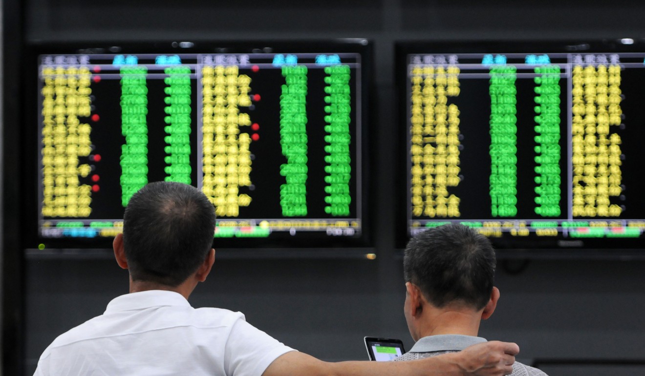Investors monitor stock prices at a securities company in Jiujiang in China's central Jiangxi province. Photo: AFP