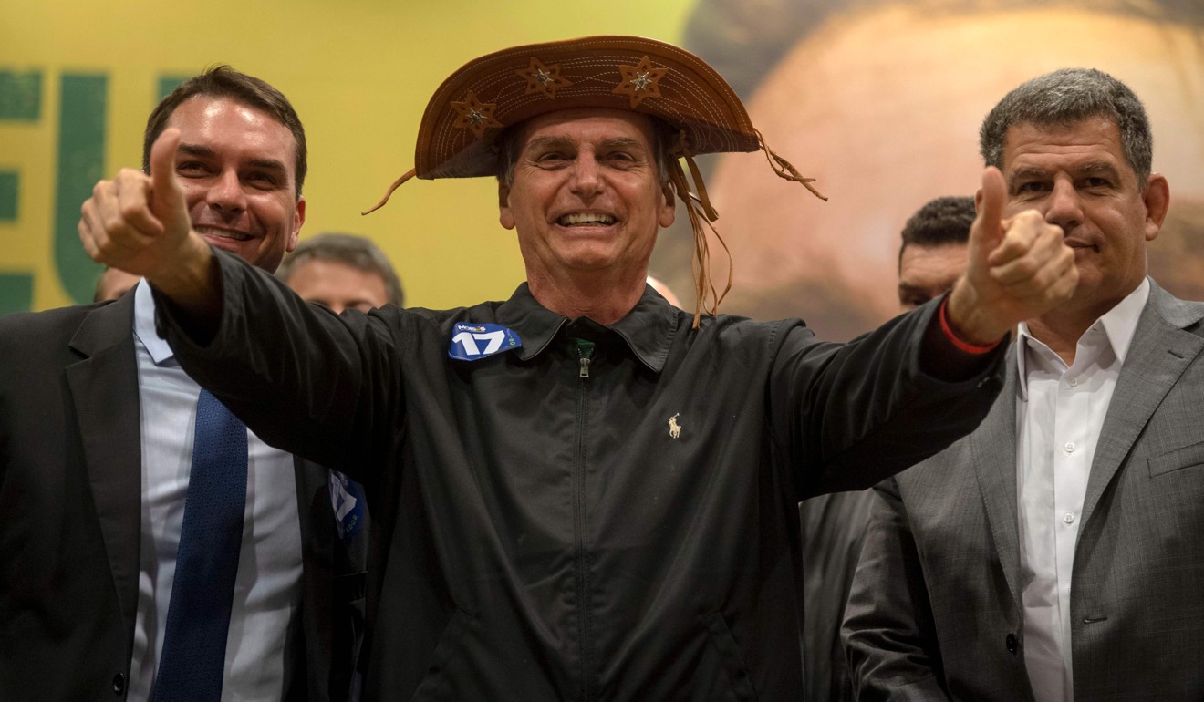 From left: Flavio Bolsonaro, Jair Bolsonaro and president of the Social Liberal Party Gustavo Bebianno, during a press conference in Rio de Janeiro, Brazil on October 11, 2018. Photo: AFP