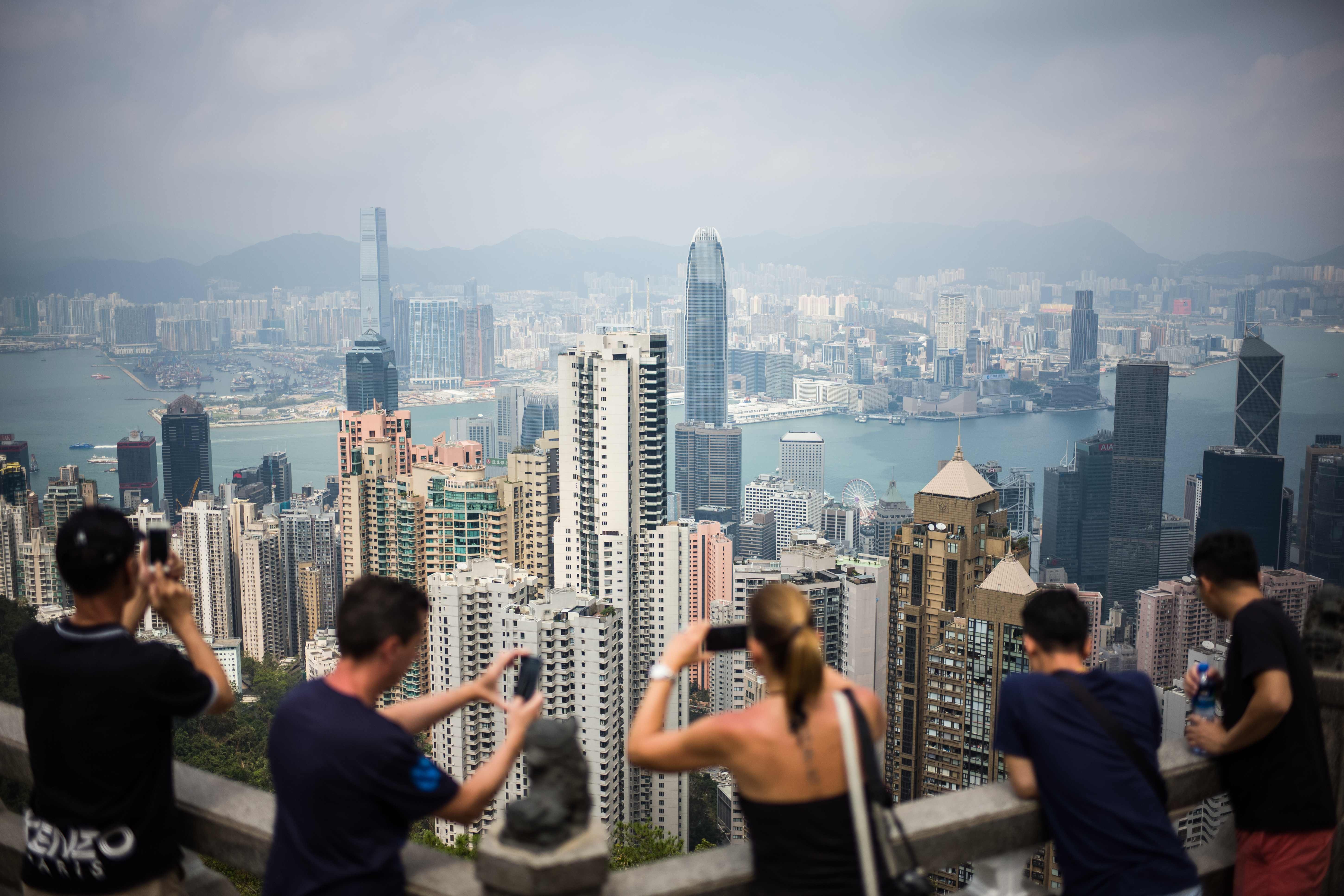 Tourists take photos on Victoria Peak, Hong Kong. Investors and property groups in Hong Kong, Singapore, mainland China and the Gulf have been moving quickly in recent months to stimulate the local proptech ecosystems. Photo: AFP
