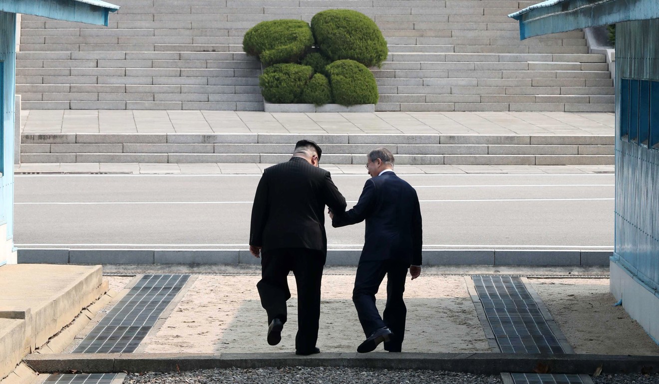 North Korean leader Kim Jong-un and South Korean President Moon Jae-in cross the military demarcation line on the demilitarised zone. Photo: EPA