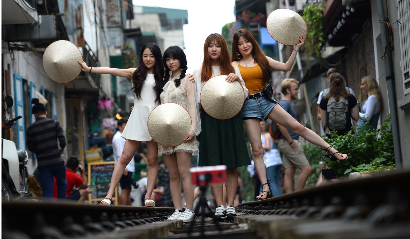 Tourists posing for a photo on Hanoi's colonial-era railway tracks. Photo: AFP