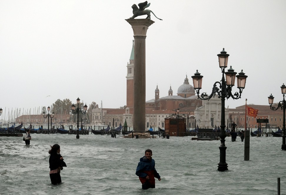 People walk in flooded Saint Mark Square during flooding in Venice on Monday. Photo: Reuters