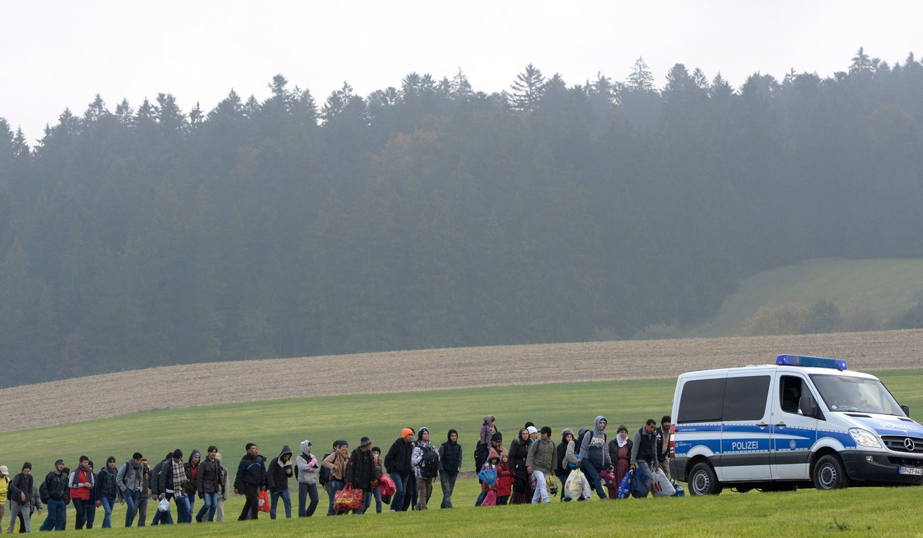A 2015 file photo of migrants walking behind a police car during their way from the Austrian-German border to the small Bavarian village of Wegscheid, southern Germany. Photo: AFP