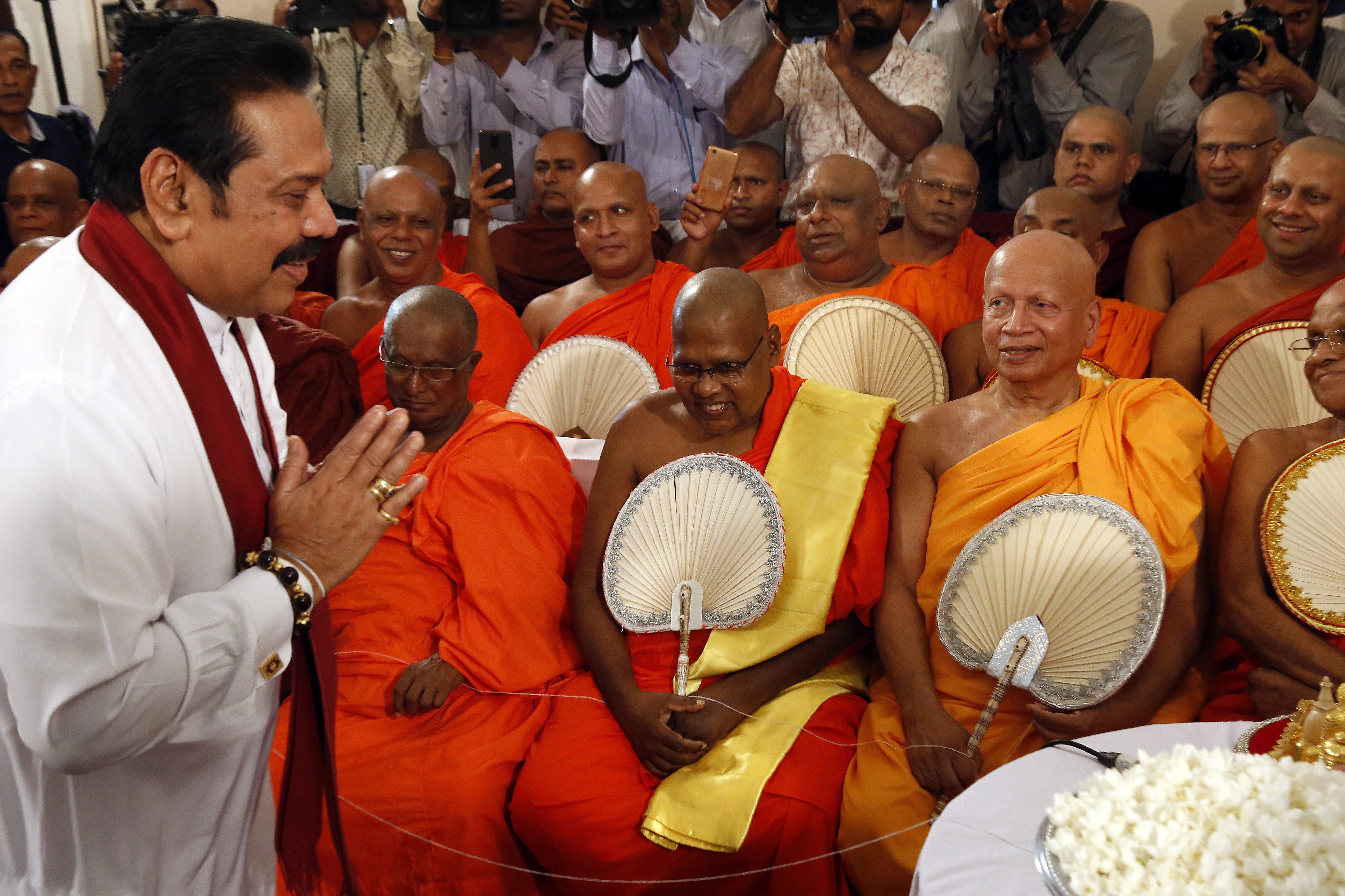 Former Sri Lankan President Mahinda Rajapaksa salutes and greets the Buddhist clergy prior to assuming duties as the new Prime Minister in Colombo, Sri Lanka. Photo: EPA