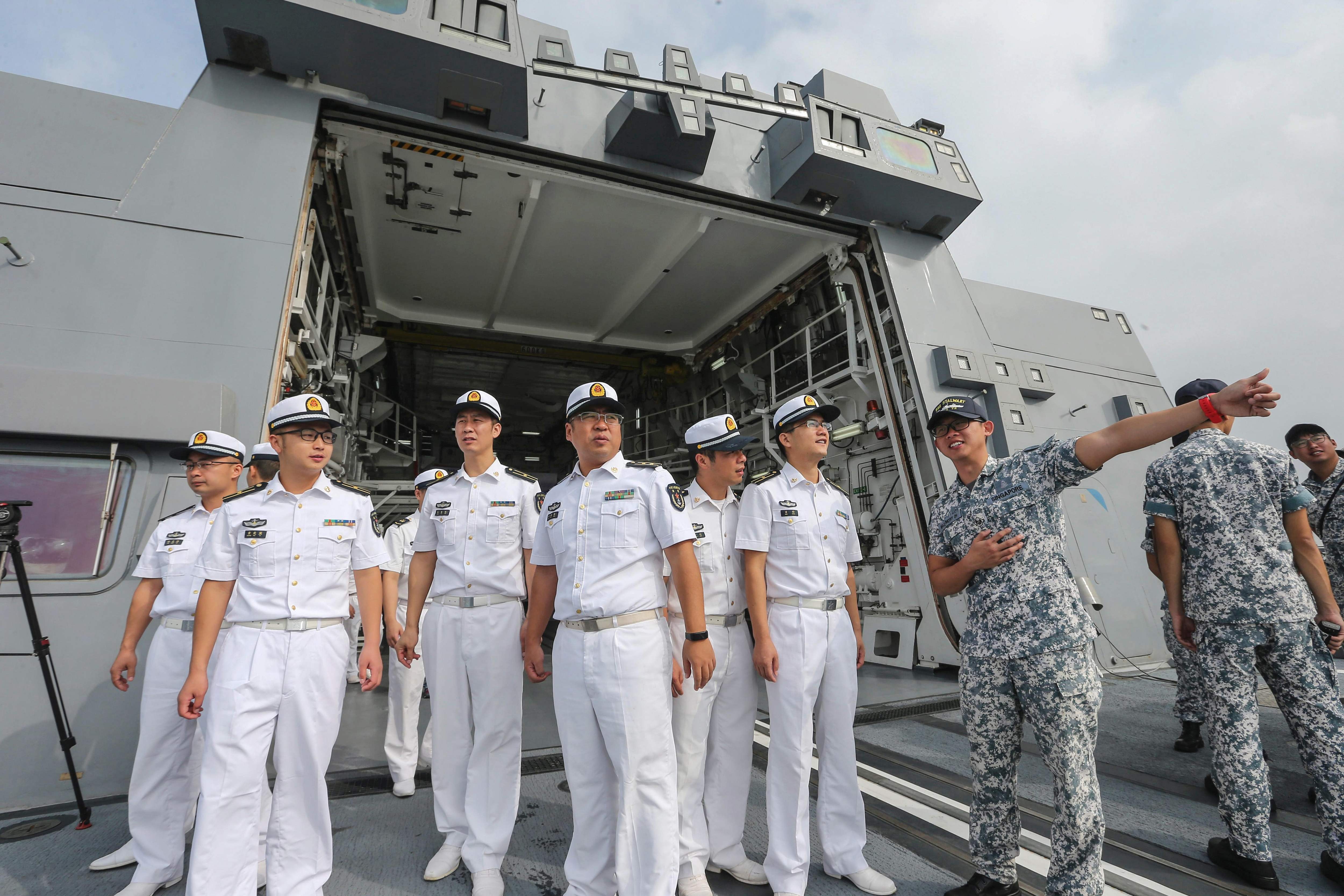 Chinese sailors (in white) visit the Singapore Navy frigate RSS Stalwart during the Asean-China Maritime Exercise at a military port in Zhanjiang, in China's southern Guangdong province, on October 24. Photo: STR / AFP