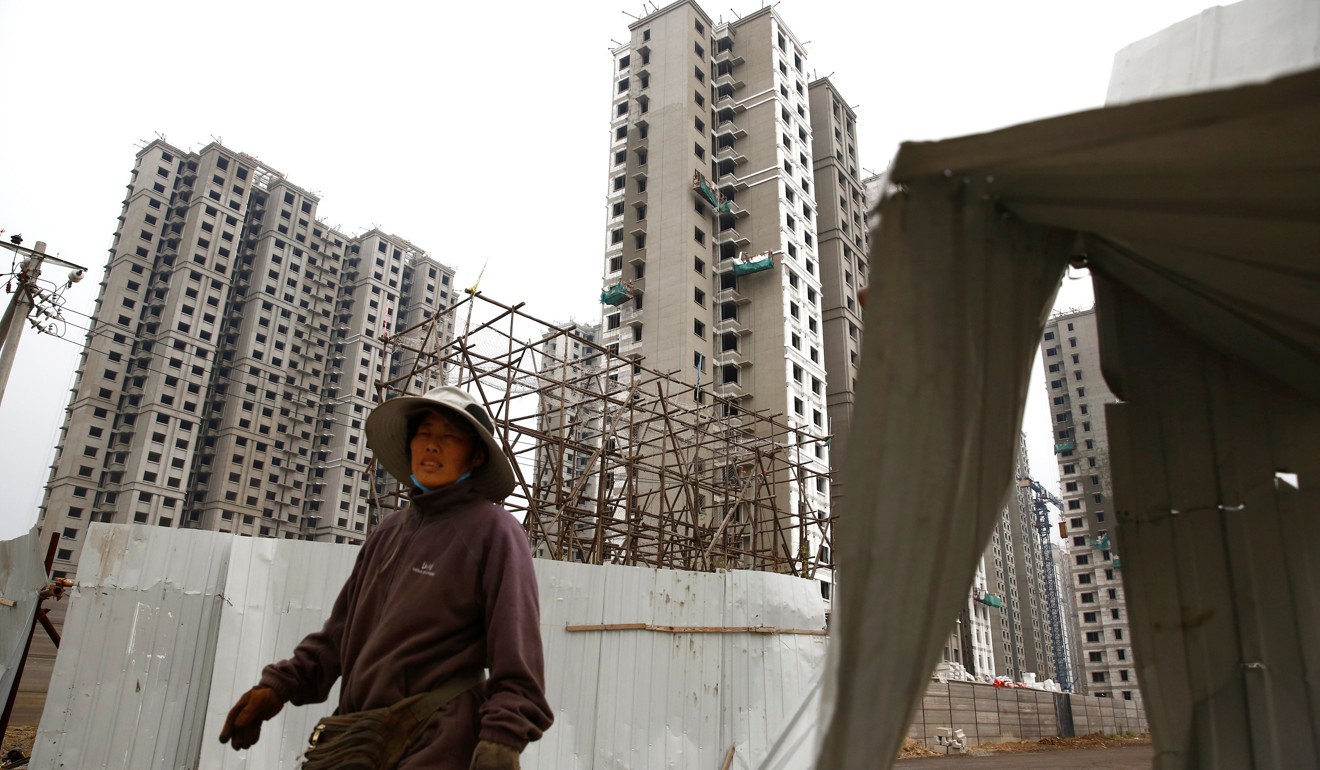 A woman walks past a construction site of residential apartment blocks in Beijing on September 27. President Xi Jinping’s call for houses to be lived in is apparently going unheeded, as a soon-to-be released report indicates that more than one-fifth of urban housing stock is unoccupied. Photo: Reuters