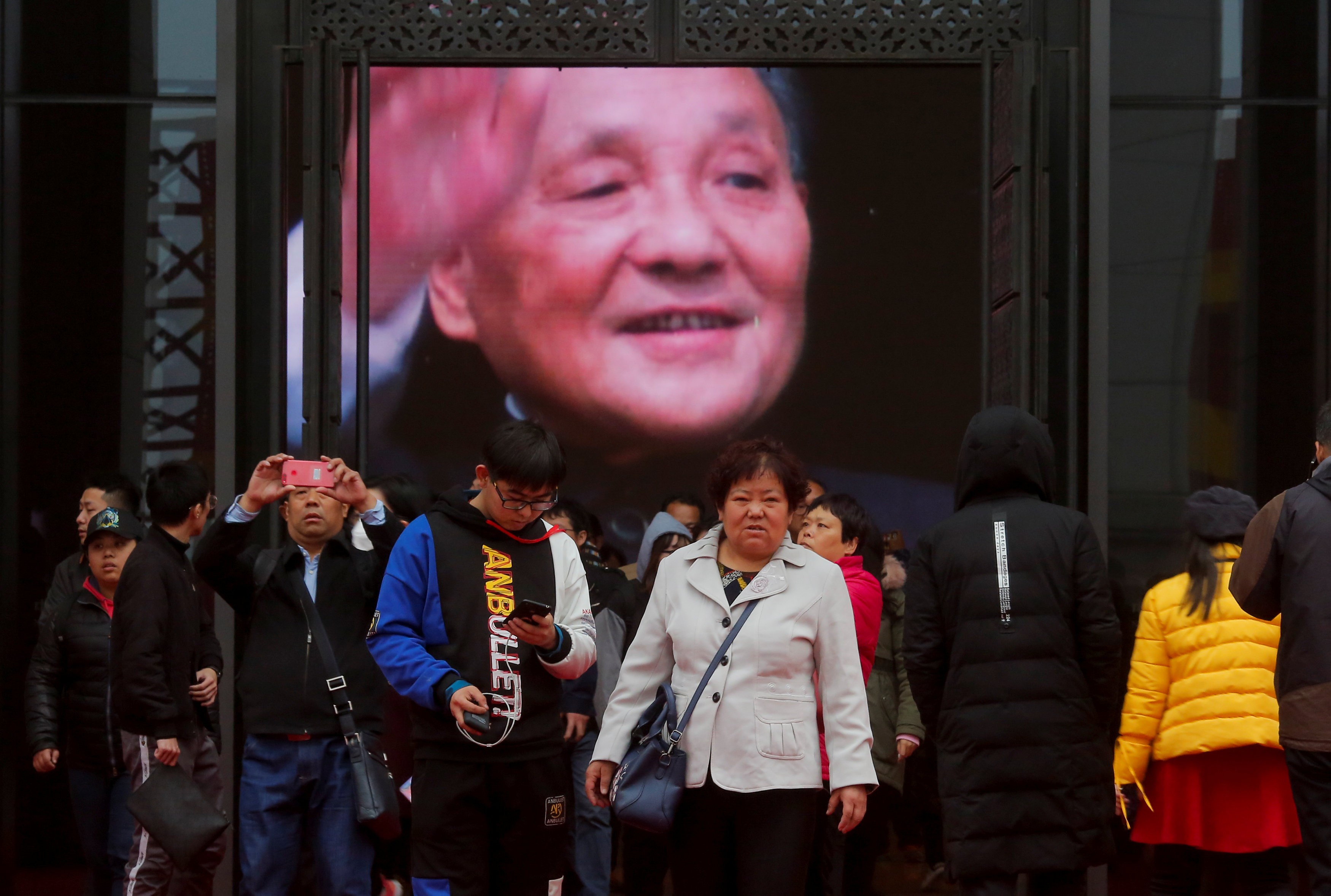 Visitors stand in front of a screen showing former Chinese leader Deng Xiaoping at an exhibition marking the 40th anniversary of China's reform and opening up at the National Museum of China in Beijing, China. Photo: Reuters/Thomas Peter