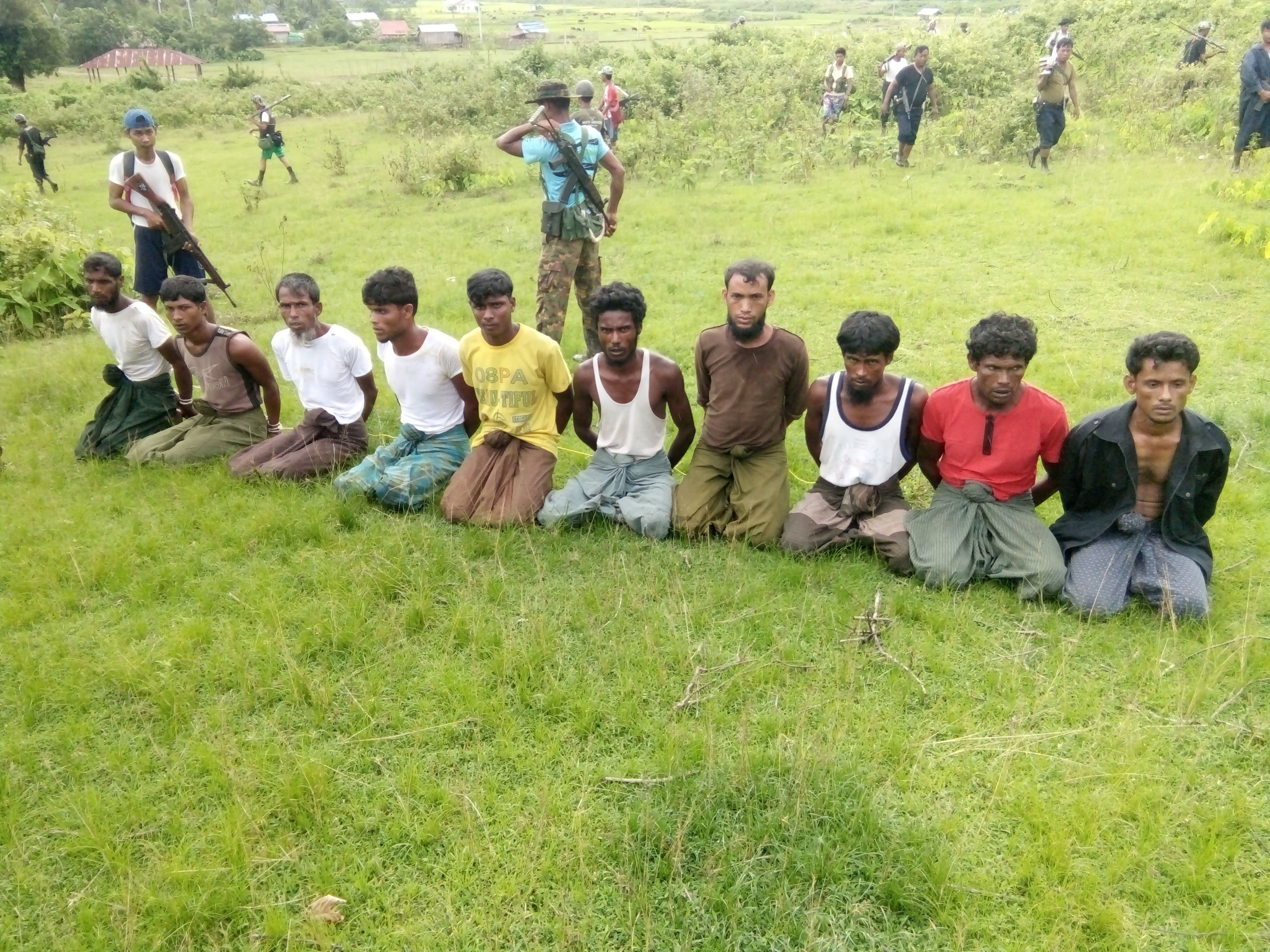 Ten Rohingya Muslim men and boys kneeling in a field in a Rakhine village last year. They were later found dead in a mass grave. Reuters reporters Wa Lone and Kyaw Soe Oo have been sentenced to seven years in jail, after investigating the killing. Photo: Reuters