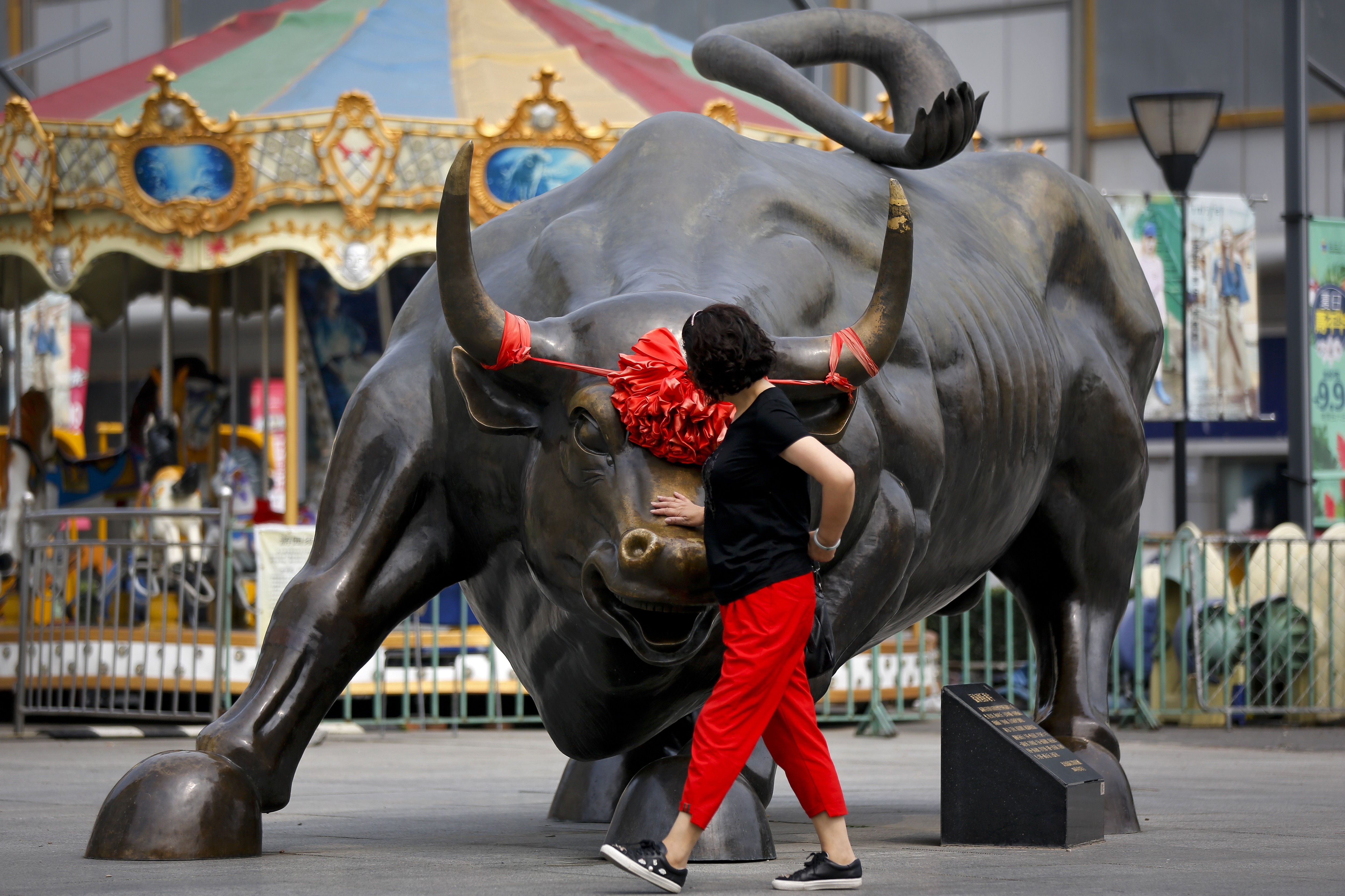 A Chinese woman touches a bull statue on display outside a mall in Beijing, in June. Data from the Institute of International Finance for the first week of November showed inflows of US$5 billion into China equities, the largest weekly total in four years. Photo: AP