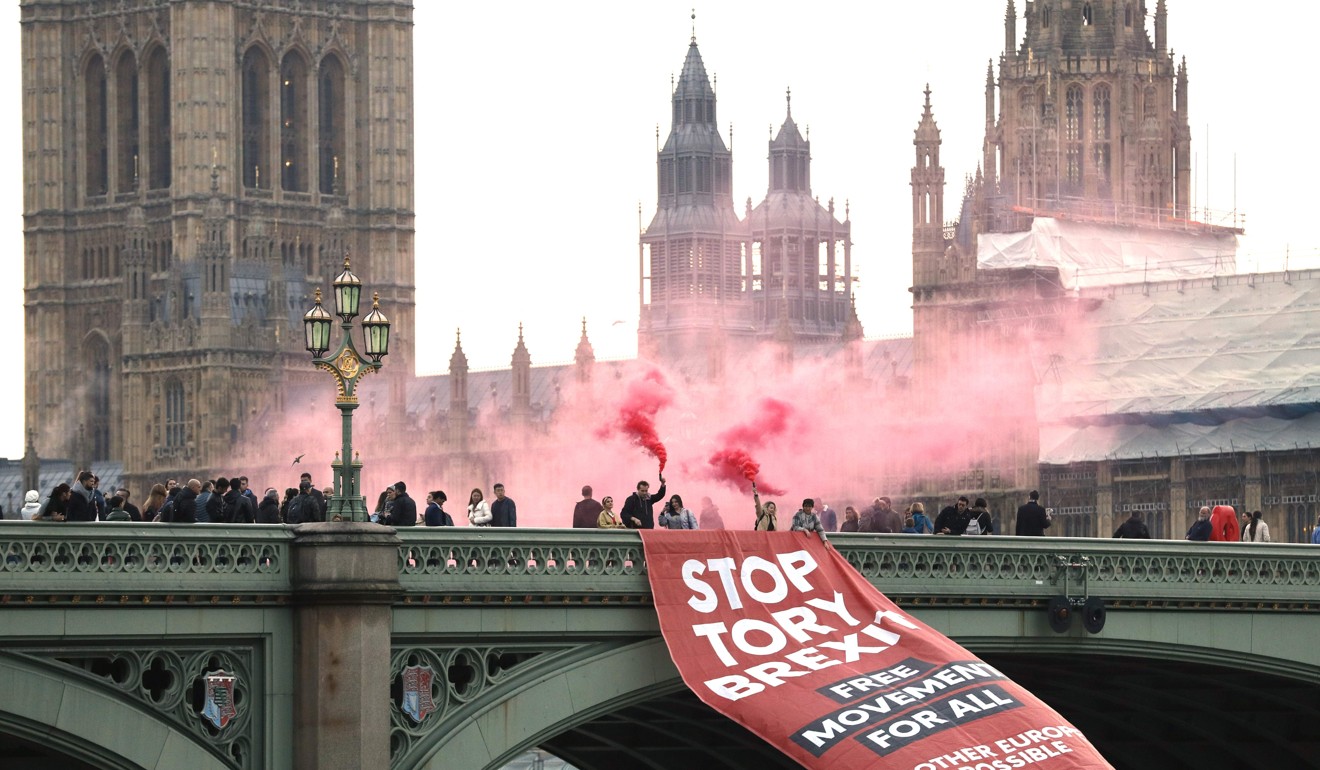 Anti-Brexit campaigners unfurl a banner on Westminster Bridge on November 15 in front of the Houses of Parliament in London. The country remains deeply divided over the decision to leave the European Union. Photo: AFP