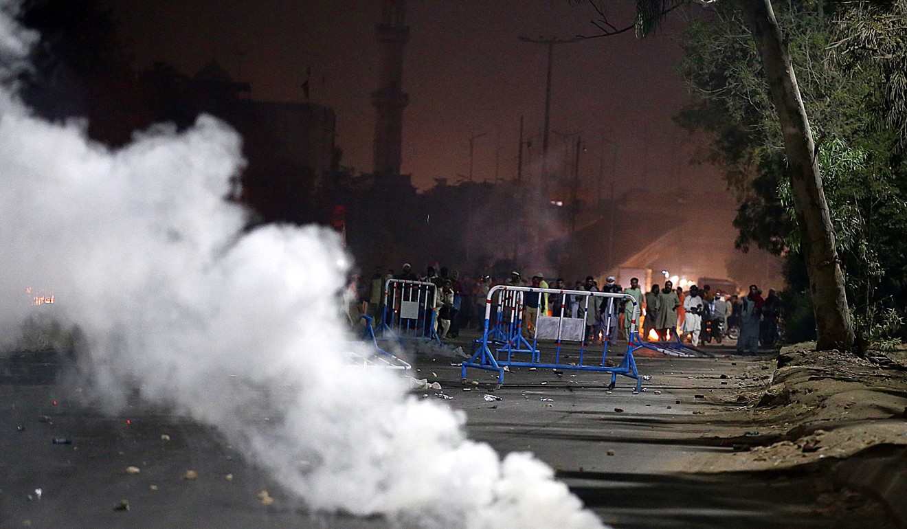Police fire tear-gas canisters to disperse supporters of Islamic political party Tehrik Labaik Ya RasoolAllah in Karachi. Photo: EPA