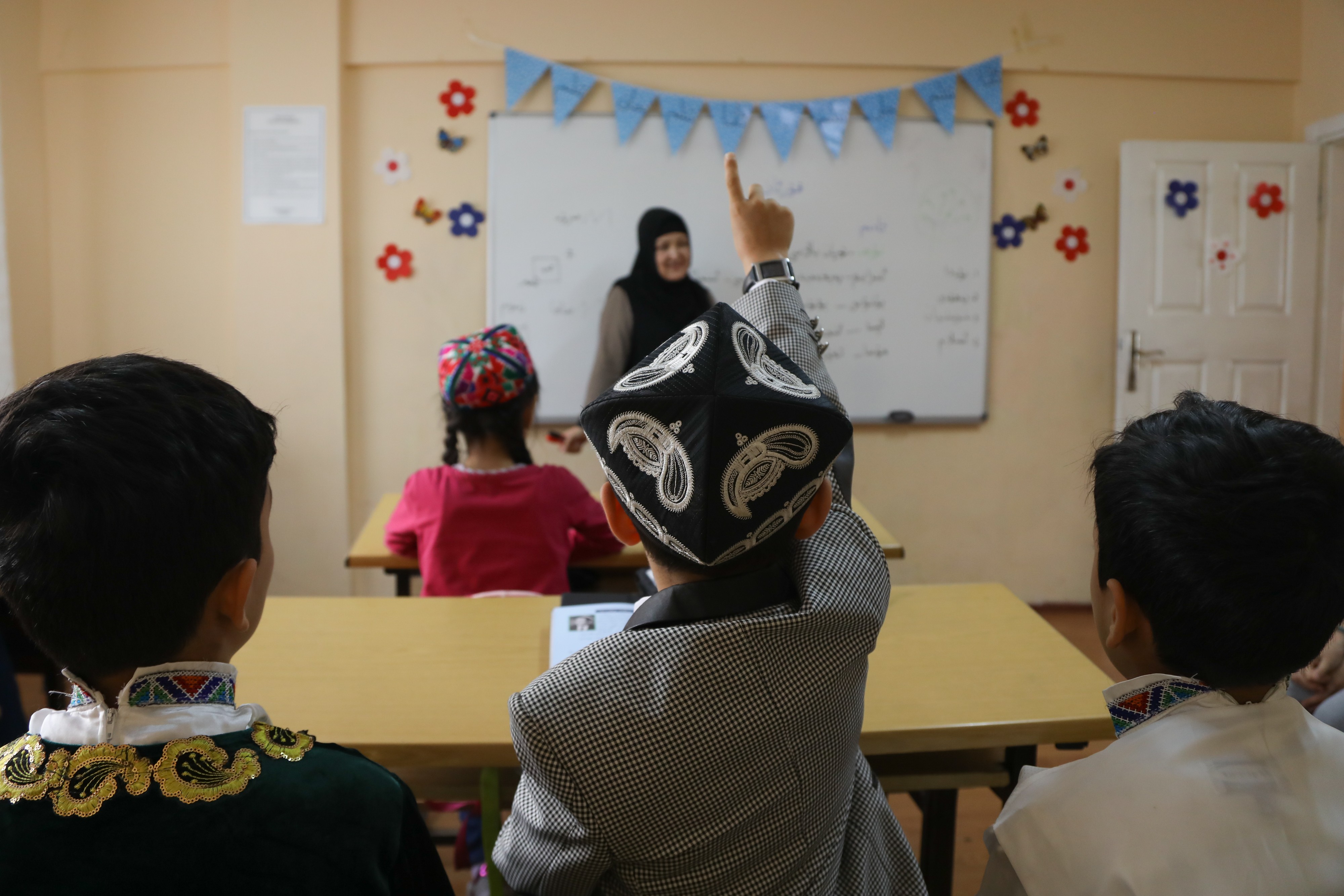 A student raises his hand in class at a Uygur school in Istanbul. Photo: Helene Franchineau