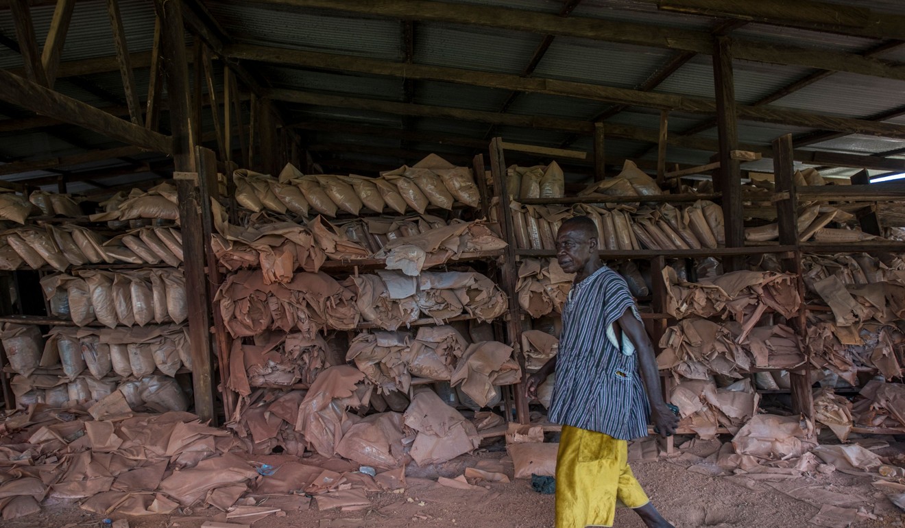 A man walks past an abandoned bauxite shed containing old samples extracted by a mining company from the Kyebi Forest Reserve to analyse the quality of its soil. Photo: AFP