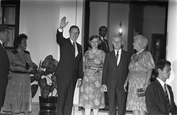 Bush (left) and his wife Barbara Bush (right) are greeted by then Governor Sir Edward Youde (second from right) and Lady Youde (second from left) at Government House in 1985.