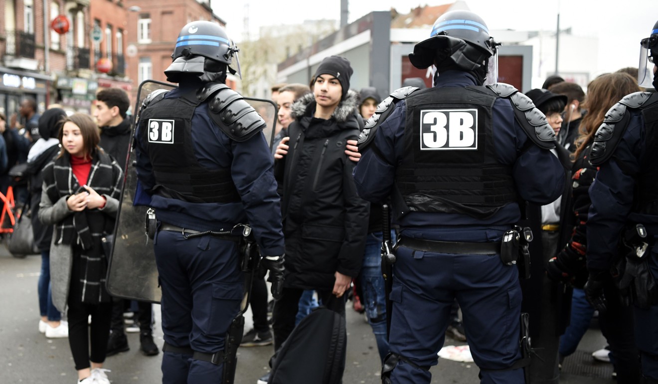 Riot police stand in front of high school students during a demonstration in front of the lycee Montebello of Lille, north France. Photo: AFP
