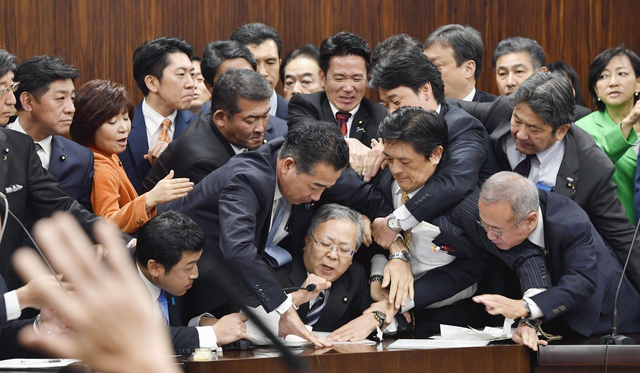 Opposition party members try to stop Judicial Affairs Committee Chairman Shinichi Yokoyama from moving to hold a vote for the bill to revise immigration control law in Tokyo on December 8, 2018. Photo: AP