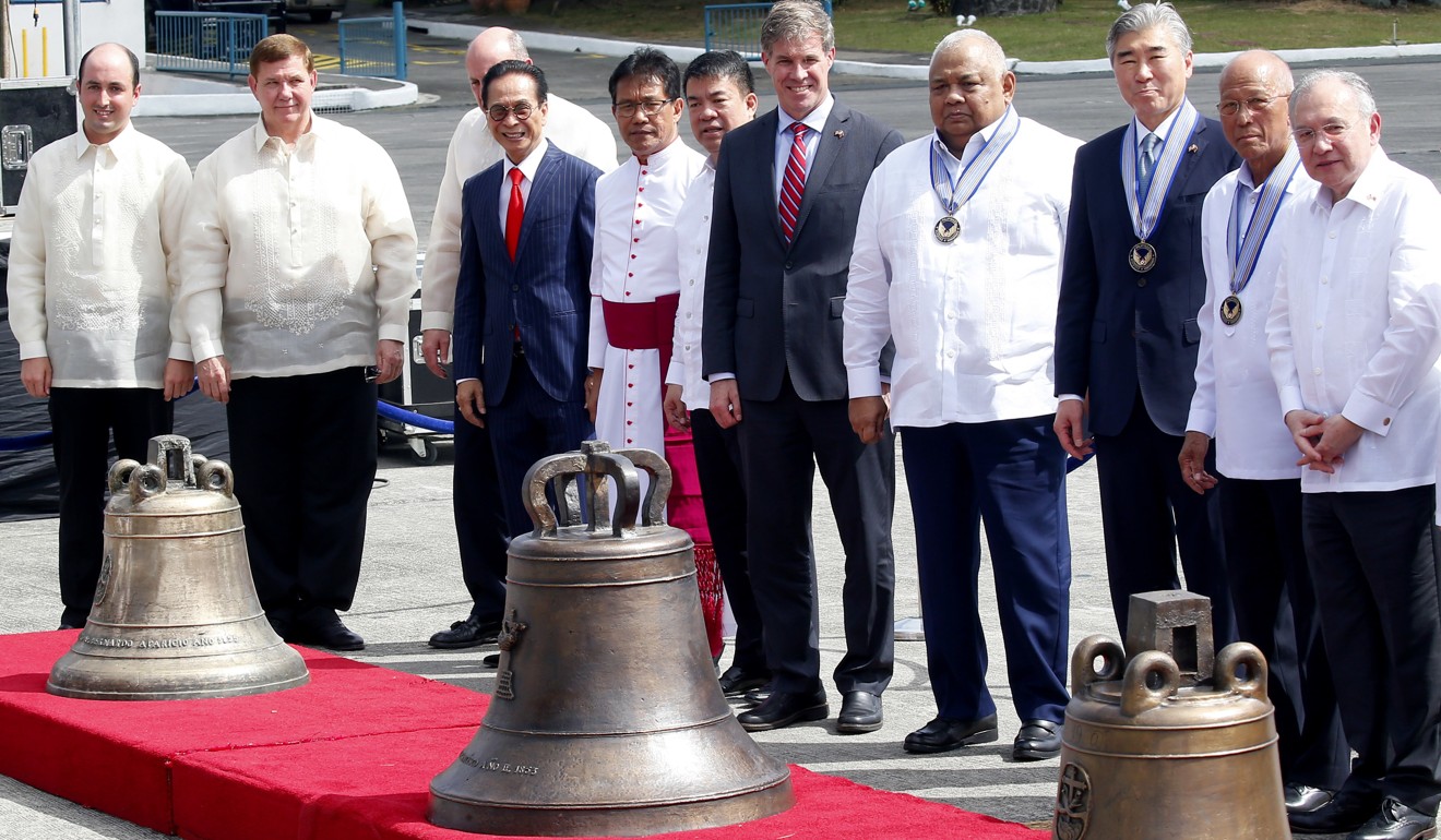 American and Philippine government officials, in Pasay city, a Manila suburb, with the three church bells during the handover. Photo: AP