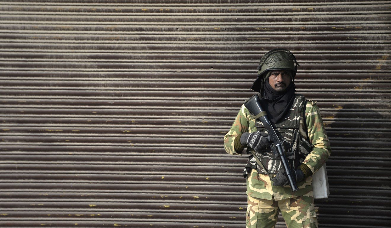 An Indian paramilitary trooper stands guard in front of a closed shop during the third day of strike called by Kashmiri separatists, in Srinagar on December 17. Photo: AFP