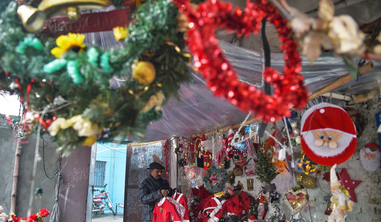 Christmas decoration seller Amjab Burgkat tidies his shop in 100 Quarters Colony, one of Islamabad's impoverished Christian ghettos. Photo: AFP