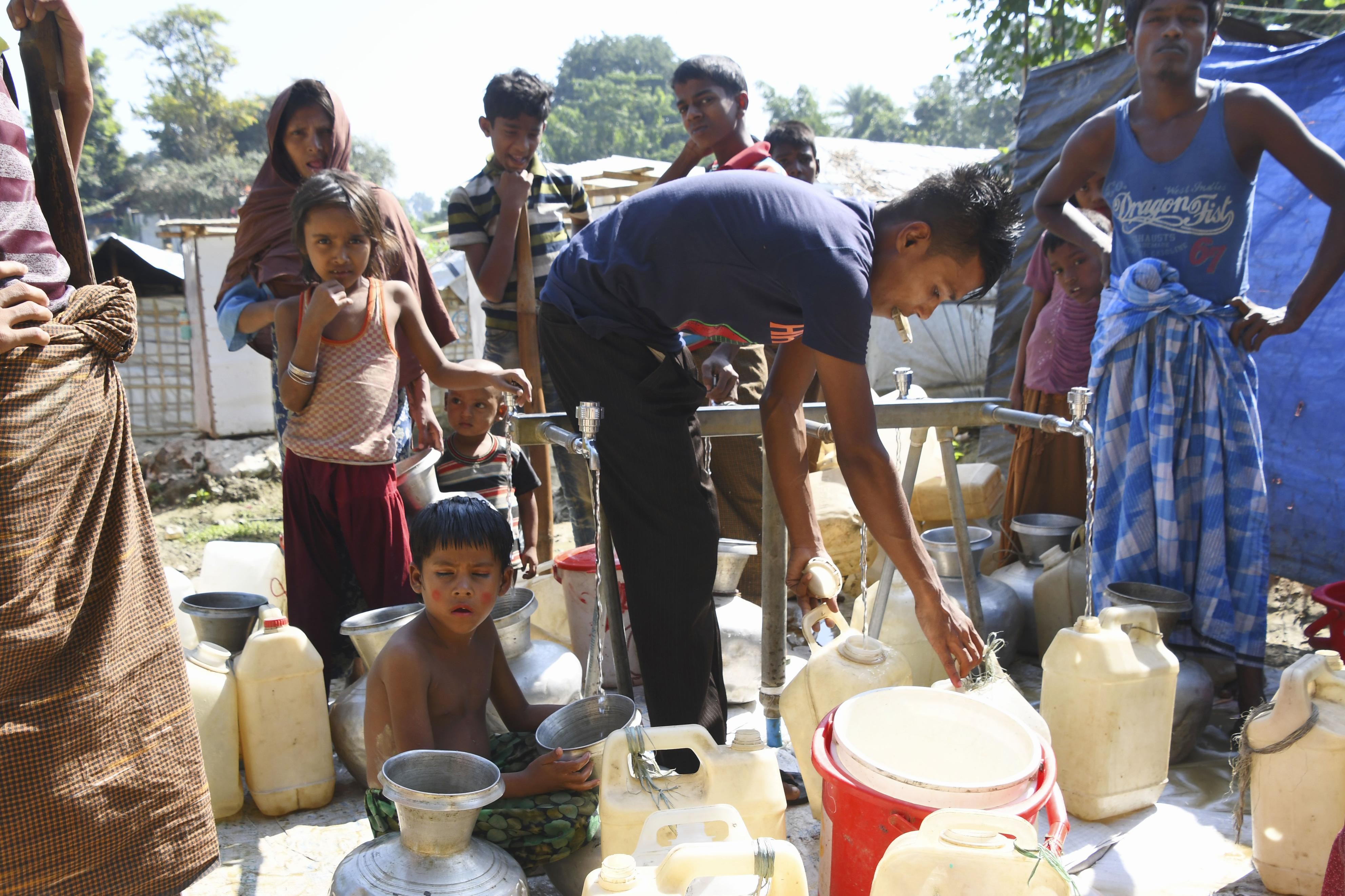 Rohingya Muslims fill water containers at a refugee camp in Cox's Bazar. Photo: Kyodo