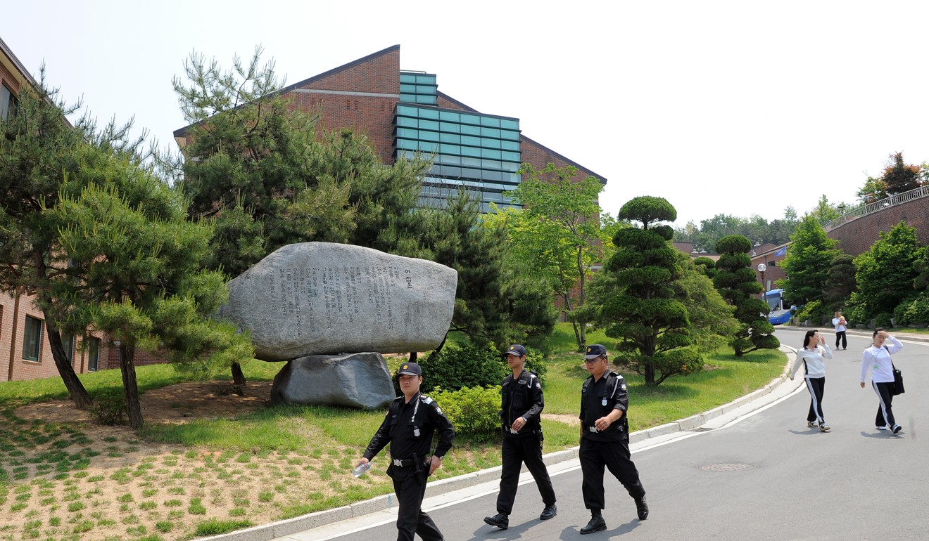 South Korean security guards walk past North Korean defectors at a Hanawon resettlement facility. Photo: AFP