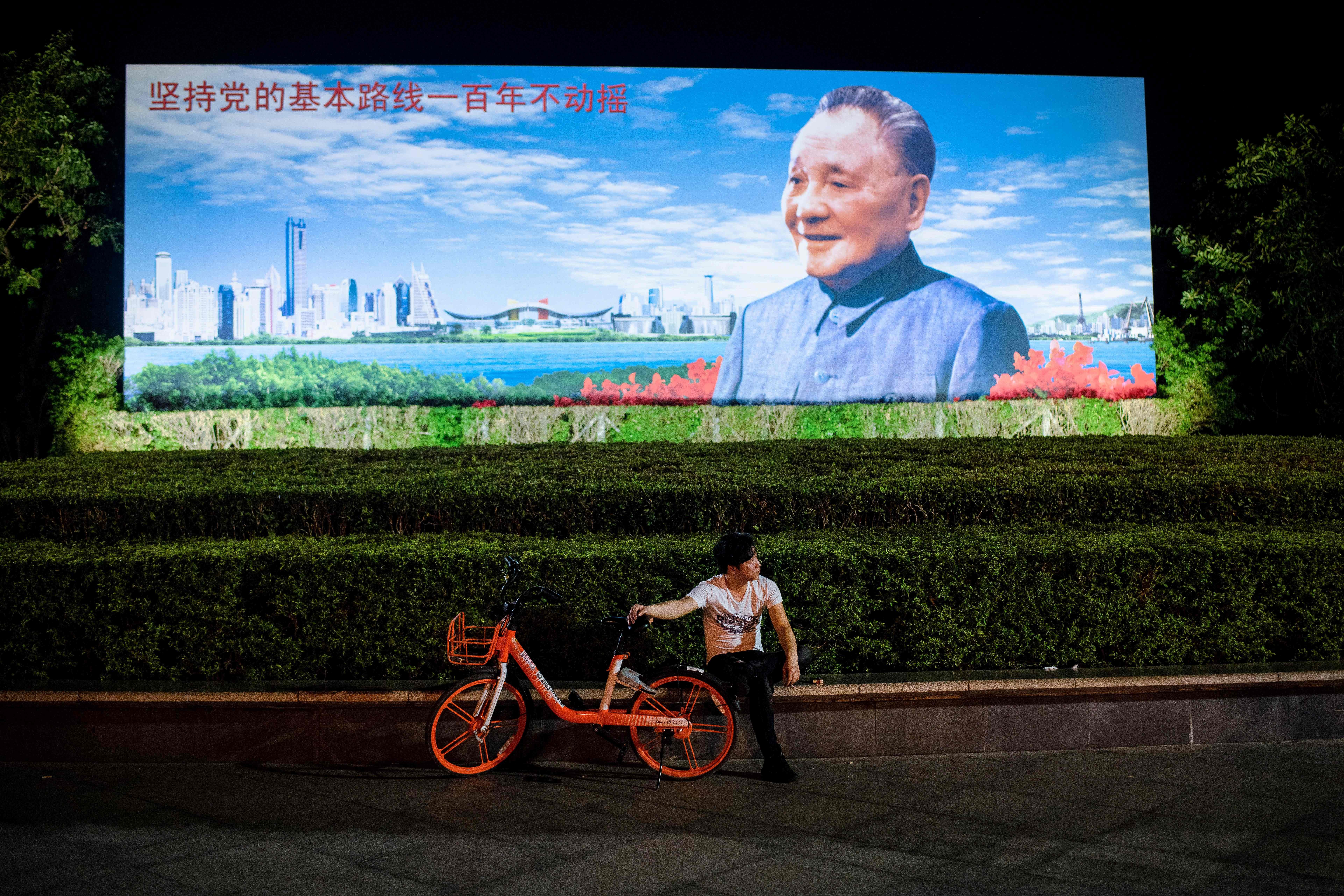 A Shenzhen resident rests in front of a poster of Deng Xiaoping in November. In December, China marked the 40th anniversary of reform and opening up, launched by Deng in December 1978, which has catapulted the country to the status of the world’s second-largest economy. Photo: AFP