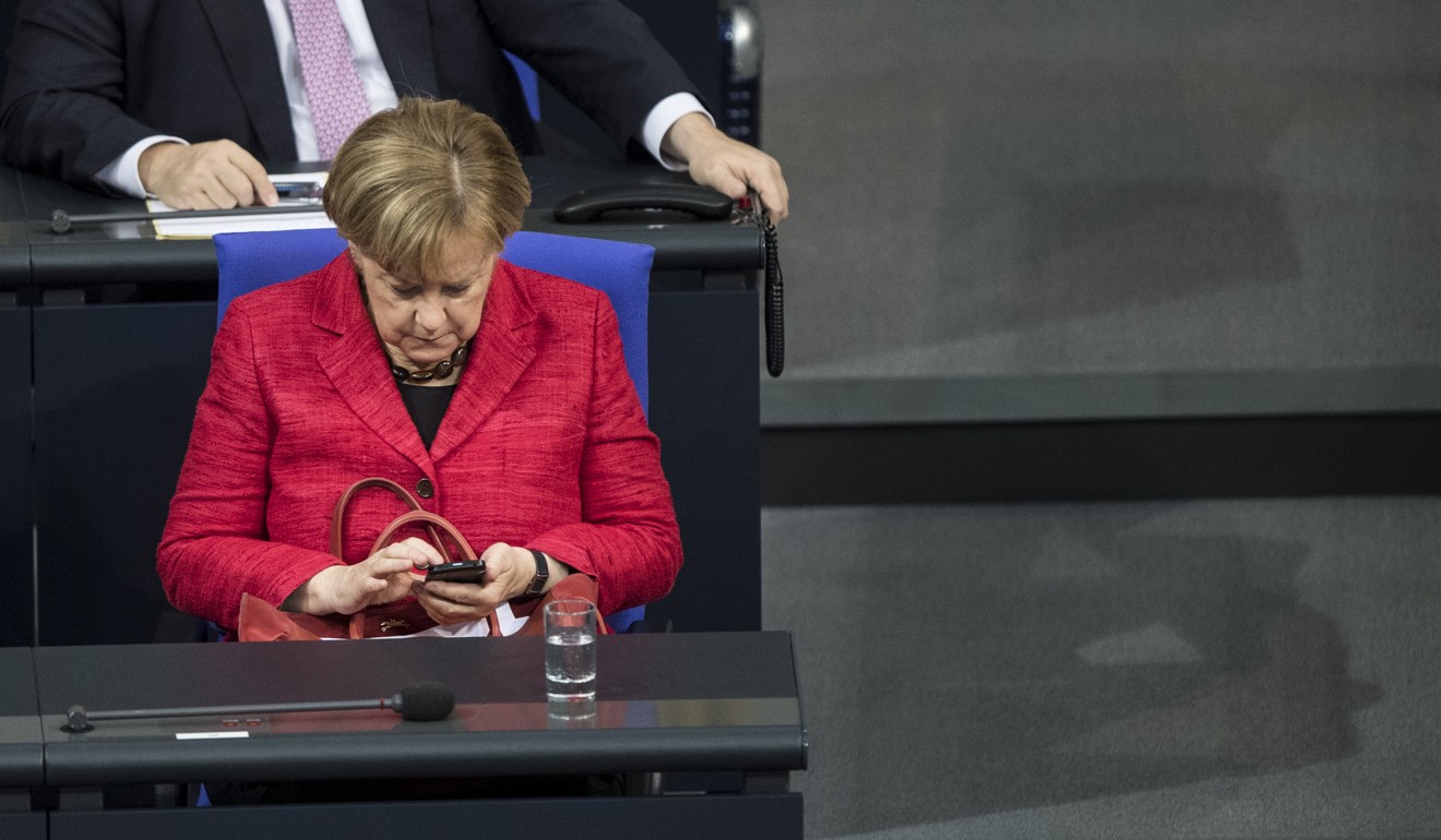 German Chancellor Angela Merkel of the Christian Democratic Union (CDU) types on her mobile phone during a session of the German Bundestag parliament in Berlin, Germany, 21 November 2017. Photo: EPA-EFE/CHRISTIAN BRUNA