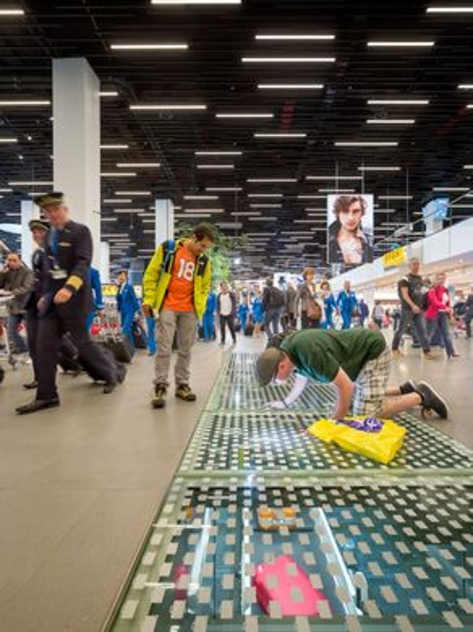 At Amsterdam Schiphol Airport, passengers in the terminal get a look at the baggage conveyor system through a clear panel in the floor. Photo: Thijs Wolzak