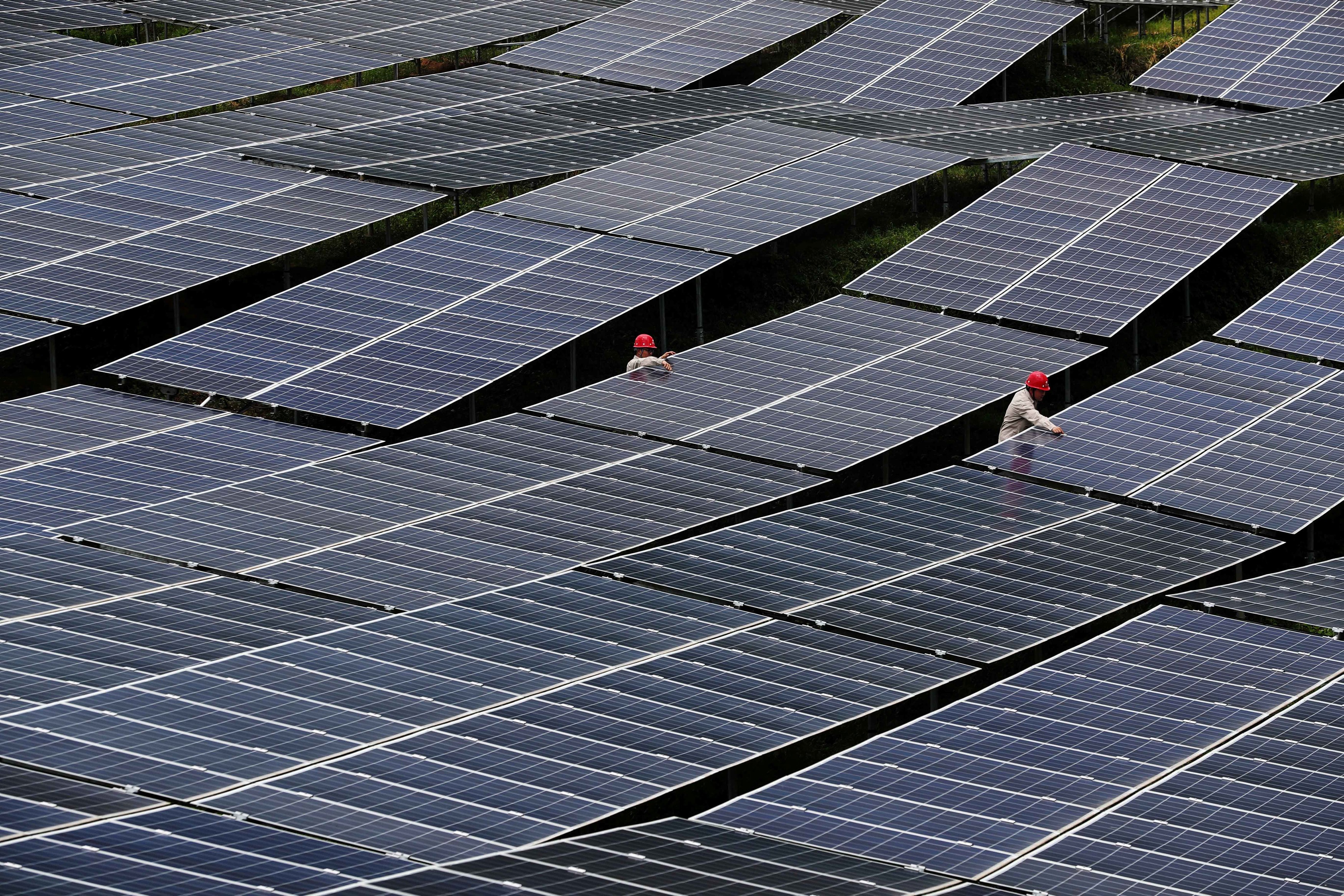 Workers check solar panels at a photovoltaic power station in Chongqing, China, in July 2018. The country installed 53GW of solar power in 2017. Photo: Reuters