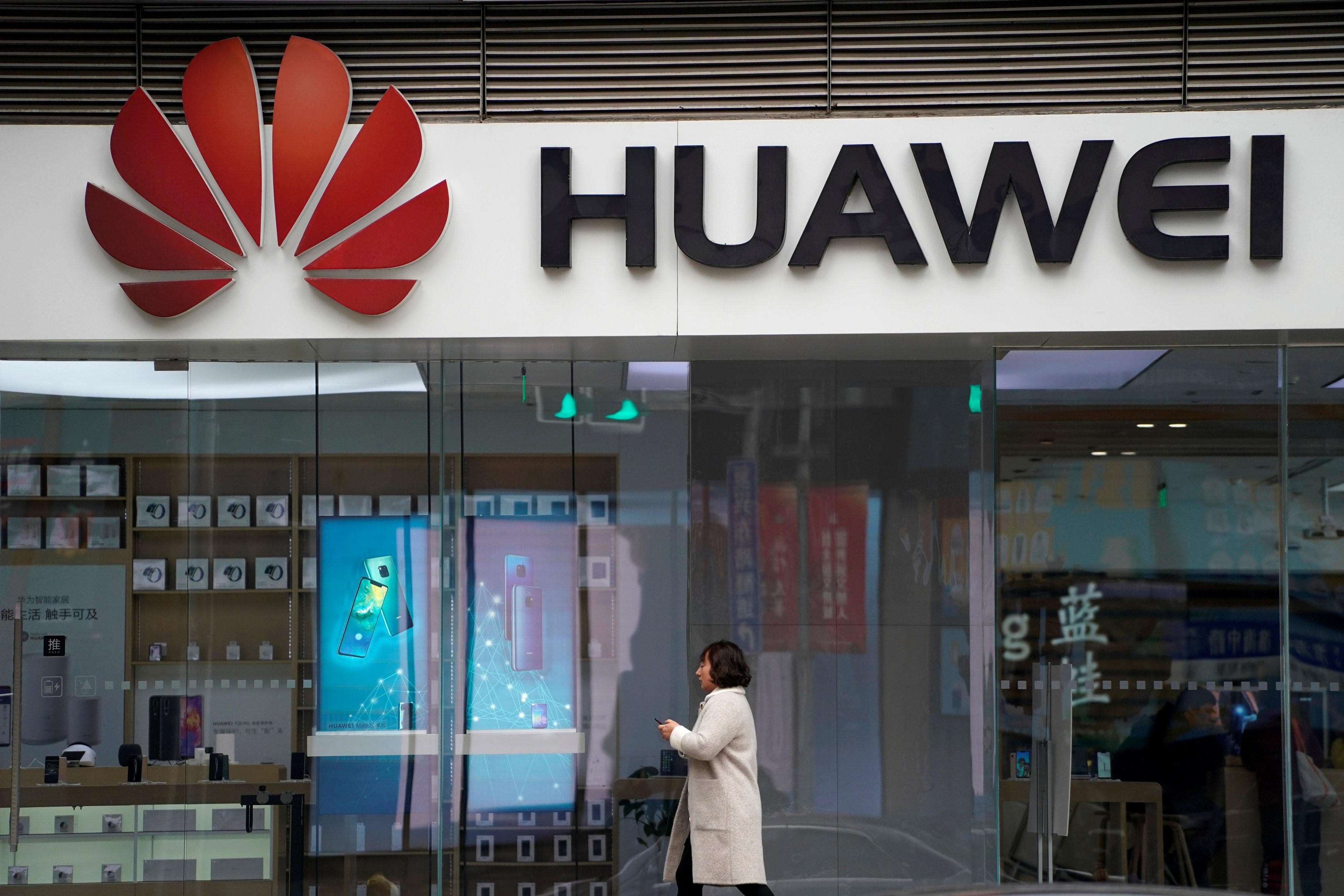 A woman walks by a Huawei logo at a shopping centre in Shanghai in December. The telecoms giant is facing increasing restrictions in countries allied with the US. Photo: Reuters