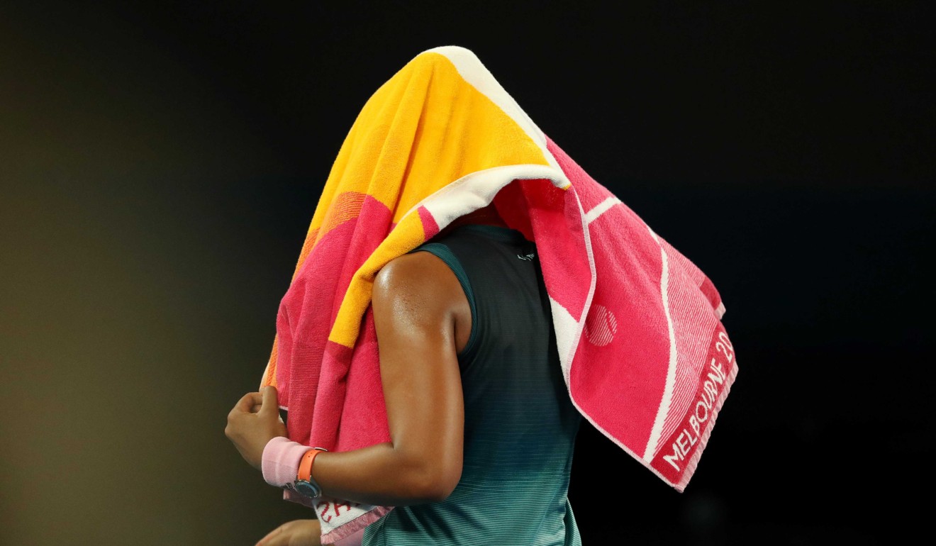 Naomi Osaka buries her head in a towel. Photo: Reuters