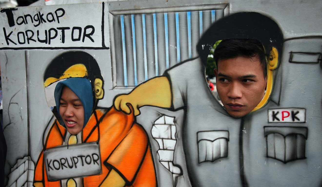 Indonesian demonstrators march with a cartoon board depicting the Corruption Eradication Commission arresting corrupt officials. The commission is considered one of the best-performing bodies of its kind in the region. Photo: AFP