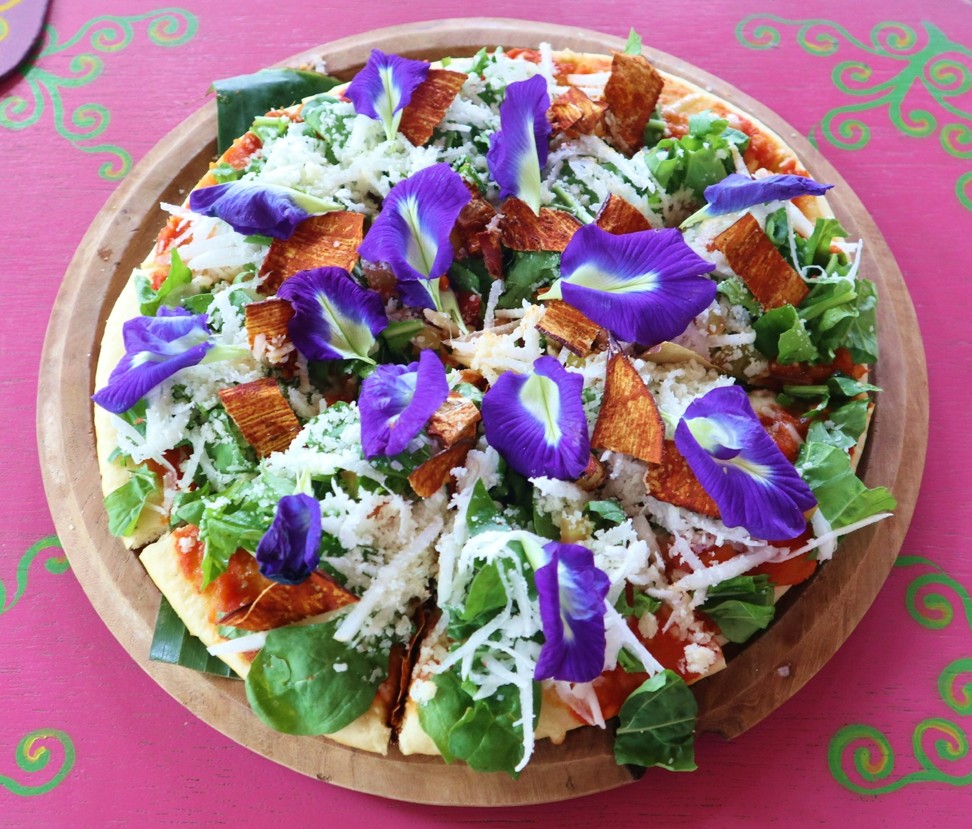 Beloved Cafe’s ‘Beloved Earth Pizza’, which includes crushed tomatoes, edible flowers, feta cheese, Emmental, Parmesan and aubergine ‘bacon’.