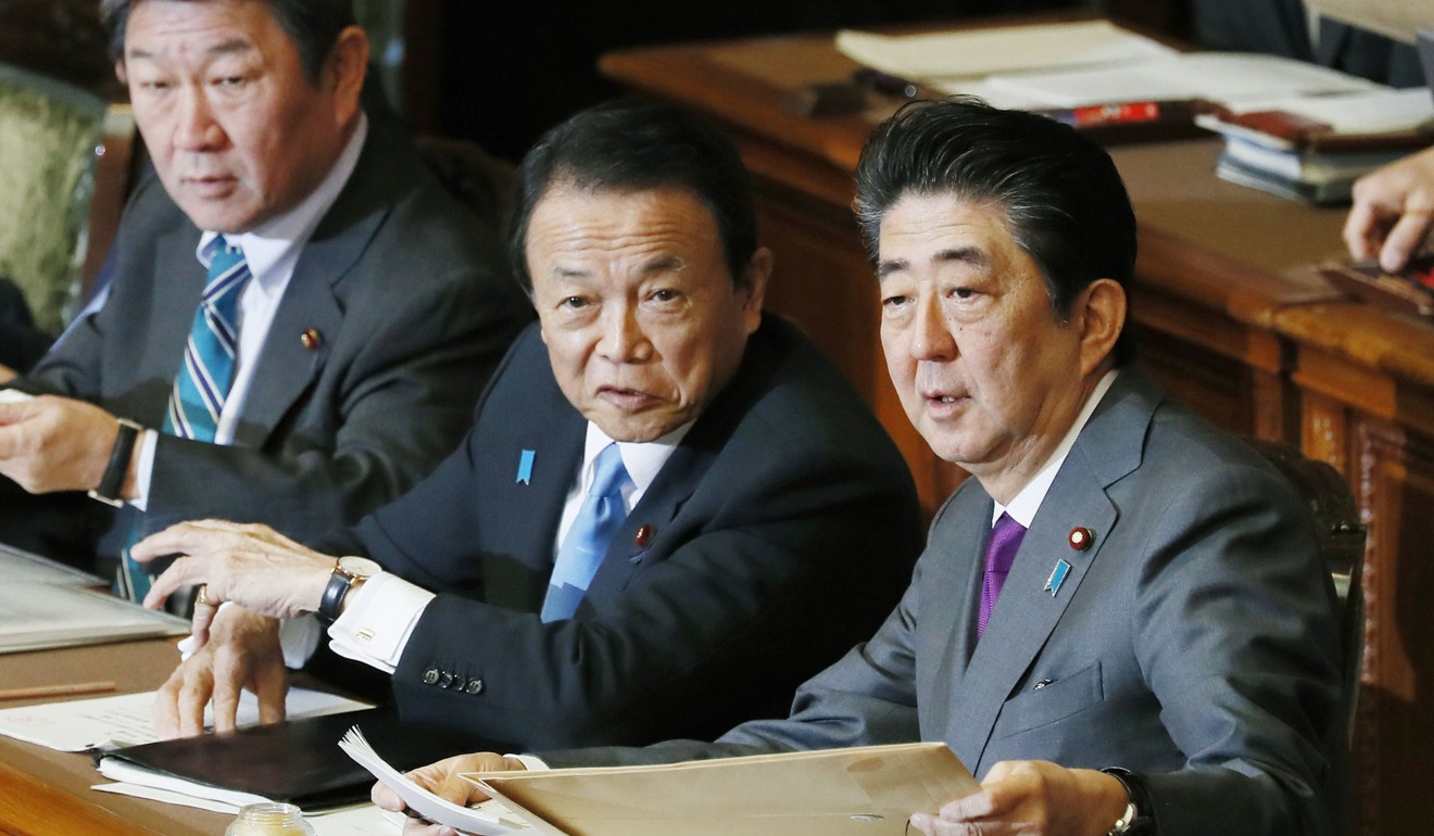Taro Aso (centre) alongside Japanese Prime Minister Shinzo Abe. Photo: Kyodo